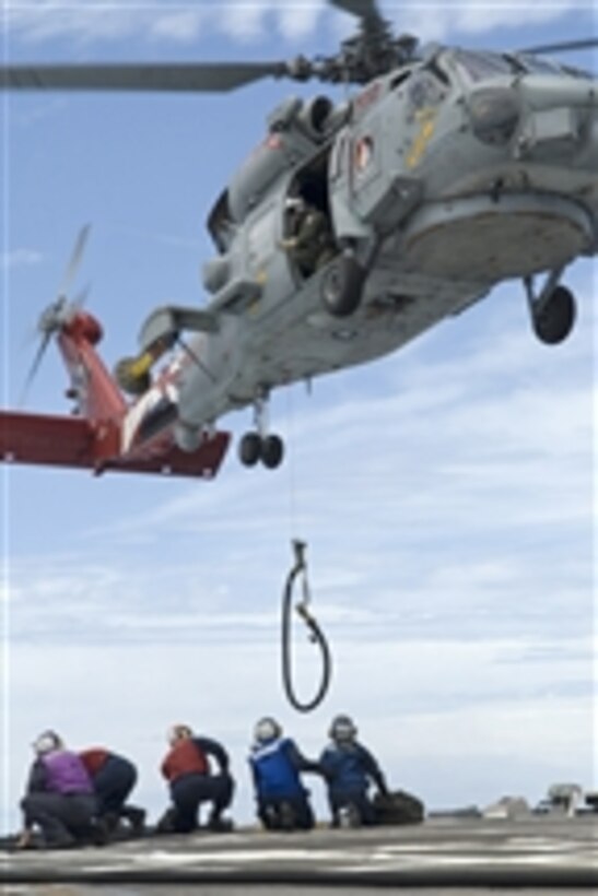 U.S. Navy sailors aboard the guided-missile destroyer USS McCampbell (DDG 85) prepare to receive a fuel line from an SH-60B Seahawk helicopter assigned to Helicopter Anti-submarine Squadron Light 51 during a helicopter in-flight refueling exercise in the Pacific Ocean on June 17, 2009.  The McCampbell is one of seven Arleigh Burke-class guided-missile destroyers assigned to Destroyer Squadron 15 and is permanently forward deployed to Yokosuka, Japan.  