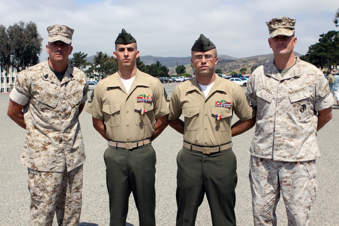 (From left to right) Sgt. Maj. Anthony Cruz Jr., sergeant major, Marine Combat Training Battalion, Staff Sgts. Shawn M. Martin and Jason M. Kuehnl, and Lt. Col.  John J. Carroll, commanding officer, MCT Bn. pose for a photo. The two staff sergeants were awarded the Navy and Marine Corps Medals during a graduation ceremony at the School of Infantry West, June 23. On two separate occasions, the Marines immediately responded to improper M67 fragmentation grenade throwing techniques and saved the lives of their students with no regard to their own lives.