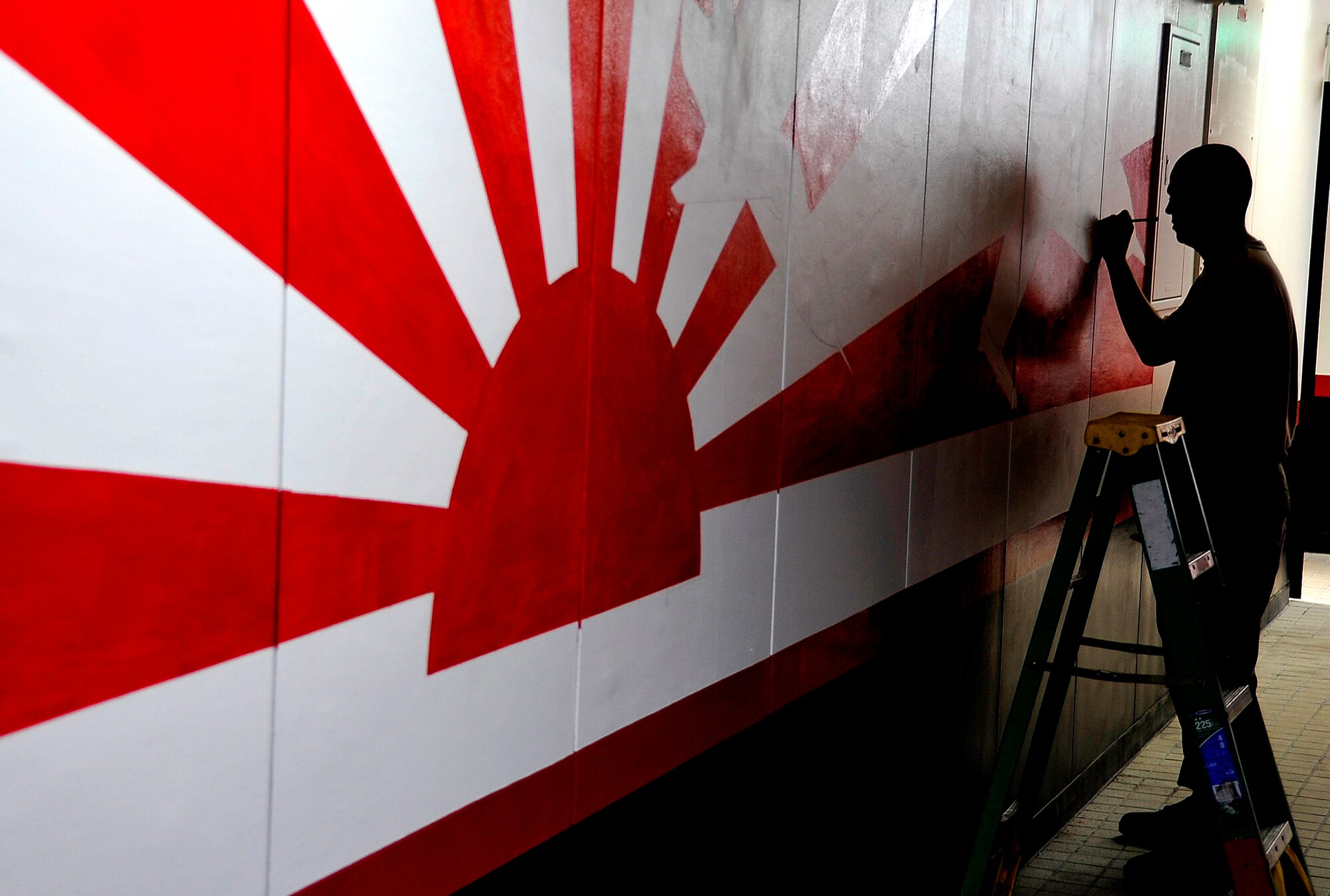 MISAWA AIR BASE, Japan -- Staff Sgt. Nicholas Romero, 14th Aircraft Maintenance Unit crew chief, paints a mural in the 13th Fighter Squadron building June 23, 2009, while the unit is deployed to South Korea. Other building improvements to the headquarters include new carpet, furniture and recreation equipment. (U.S. Air Force photo by Senior Airman Chad C. Strohmeyer) 