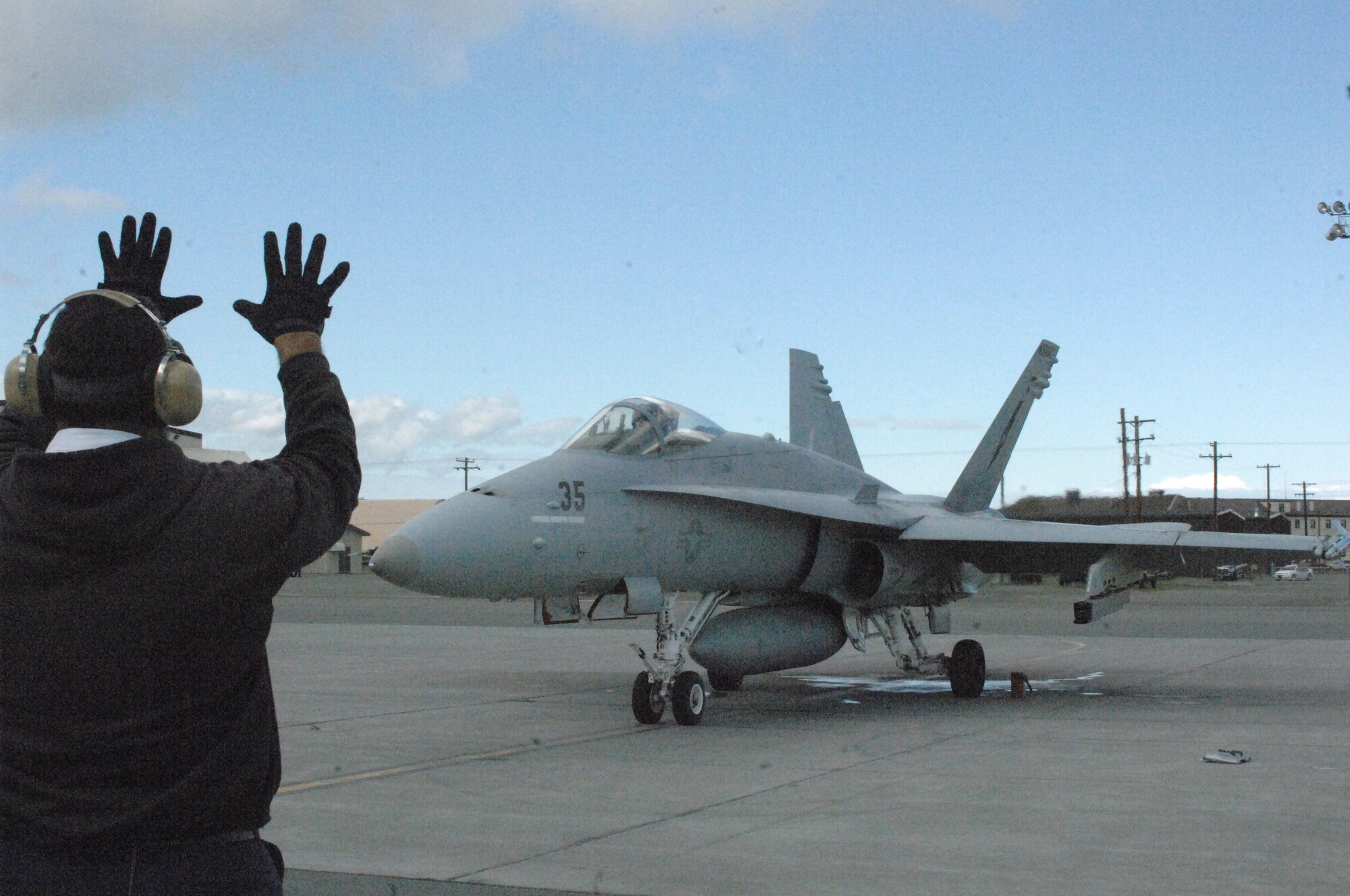 A flight operator instructs Navy Lt. Michael Patterson, a pilot with the Navy Strike Air Warfare Center, to proceed for takeoff down the runway June 24 at Elmendorf Air Force Base, Alaska. (U.S. Army photo/Sgt. Ricardo Branch)
