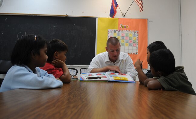 Tech. Sgt. Raven Worley, 525th Expeditionary Aircraft Maintenance Unit weapons load crew team chief, reads to kindergarten and first graders at Machananao Elementary School.  The Fort Oglethorpe, Ga., native is deployed to Andersen Air Force Base from Elmendorf AFB, Alaska, to support U.S. Pacific Command's Continuous Bomber Presence in the Asia-Pacific Region. (U.S. Air Force photo/ Senior Airman Christopher Bush)
