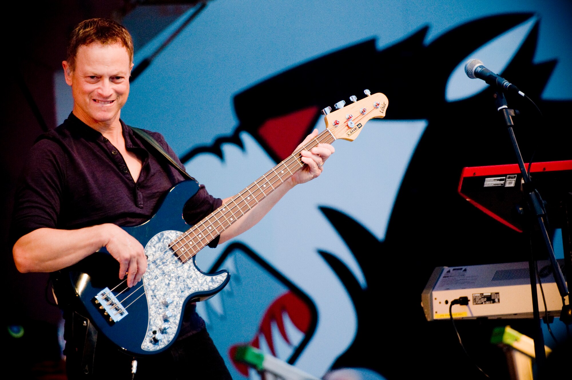 KUNSAN AIR BASE, Republic of Korea -- Gary Sinise, the bassist for the Lt. Dan Band, plucks the base guitar June 24. The Lt. Dan Band performed for approx. 900 Wolf Pack members during the concert. Kunsan Air Base, Republic of Korea is just one stop on their Asia USO tour this summer. (U.S. Air Force photo by Senior Airman Jonathan Steffen)