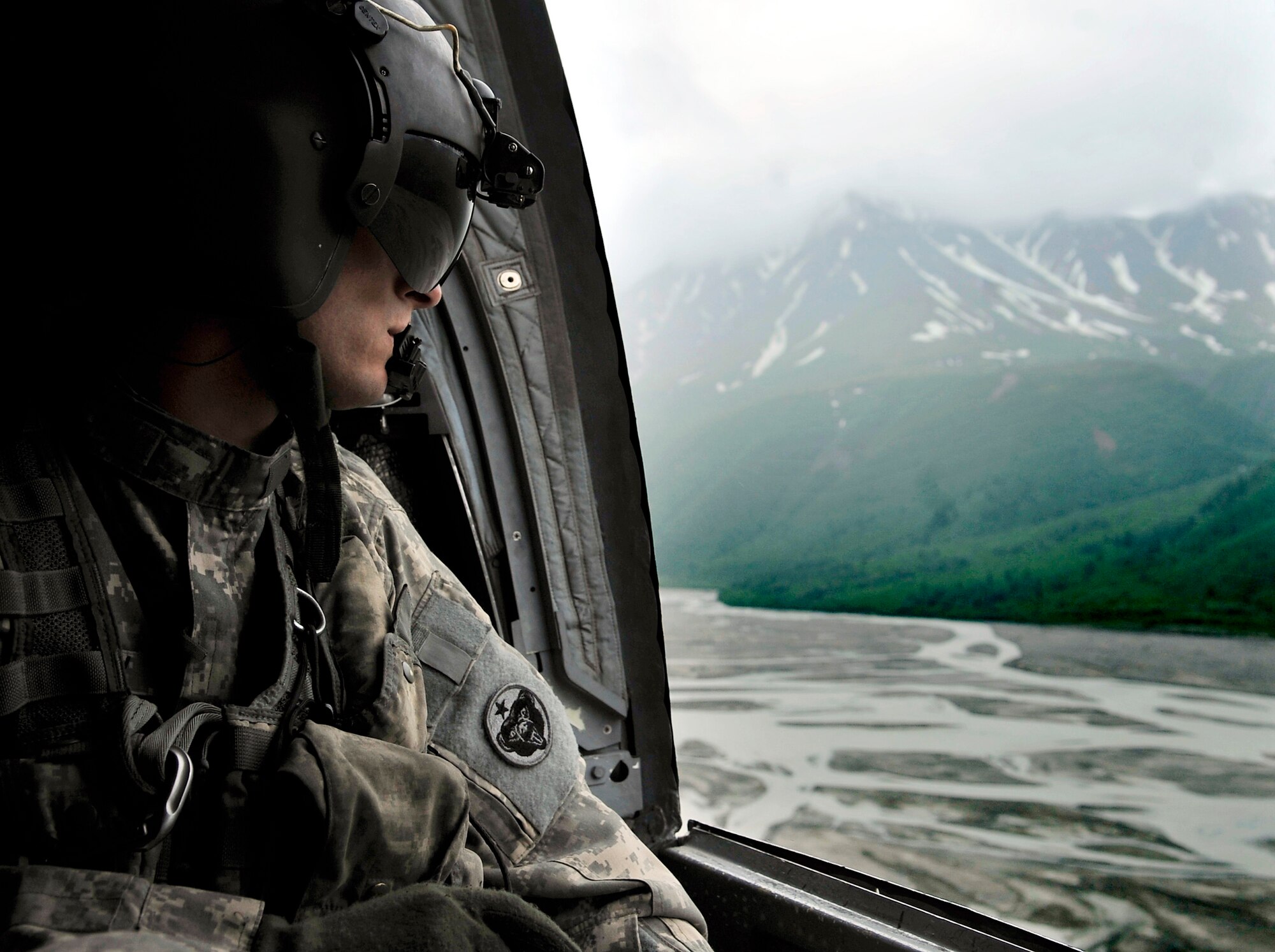 Army Sgt. William Penley looks over the Alaskan terrain in a CH-47 Chinook during Northern Edge 2009  June 17 at Fort Wainwright, Alaska. Northern Edge is a large-scale exercise hosted in Alaska to improve command, control and communications between the armed services. Sergeant Penley is a flight engineer assigned to Bravo Company 152 at Fort Wainwright. (U.S. Air Force photo/Staff Sgt. Christopher Boitz)