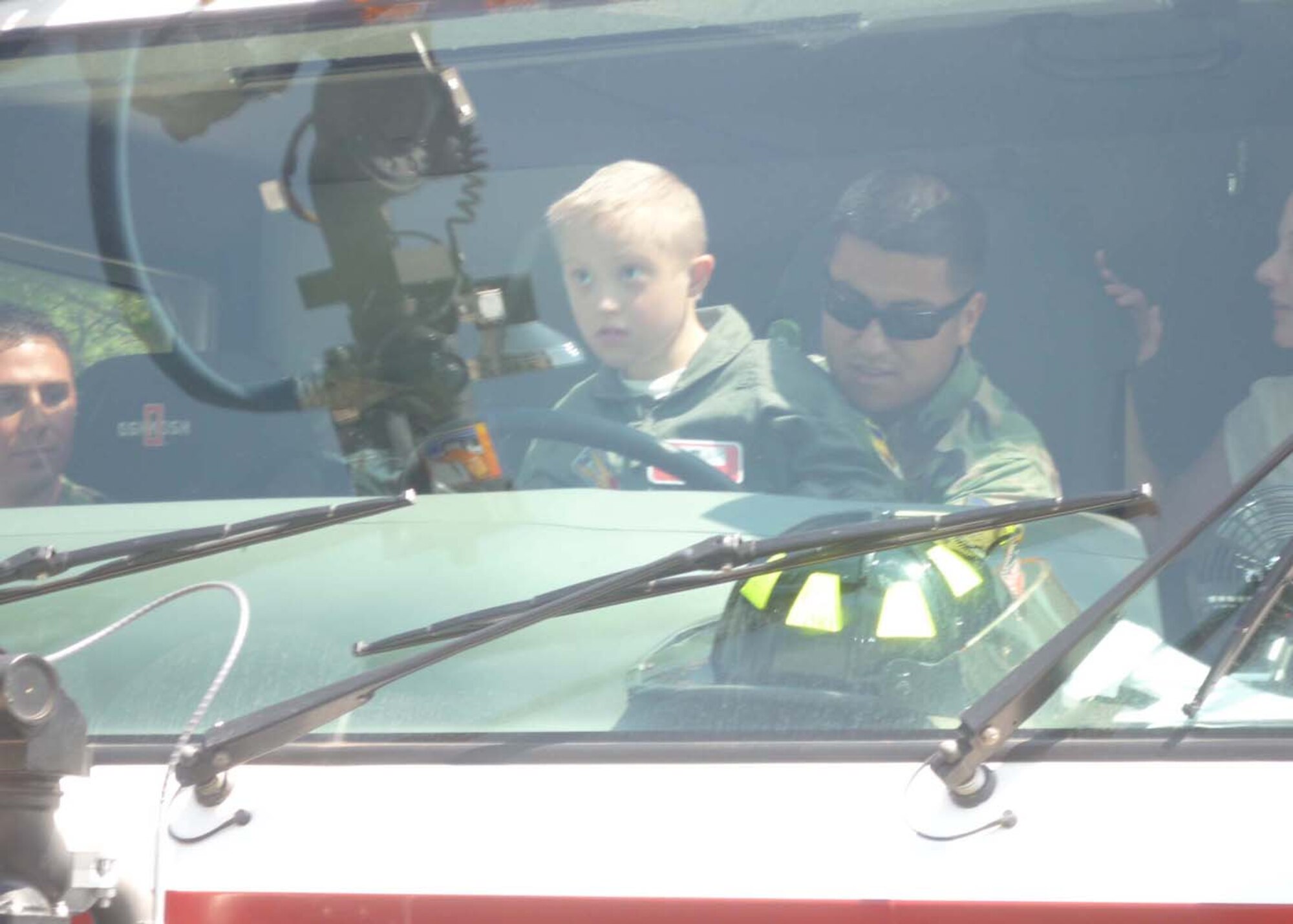SHAW AIR FORCE BASE, S.C. - Eight-year-old Devon Nekic takes his turn at the controls of a fire truck here as a part of the 'pilot for a day' program. A Shaw fireman shows Devon how to work the fire hoses on the truck before returning to the fire station. (Courtesy photo)