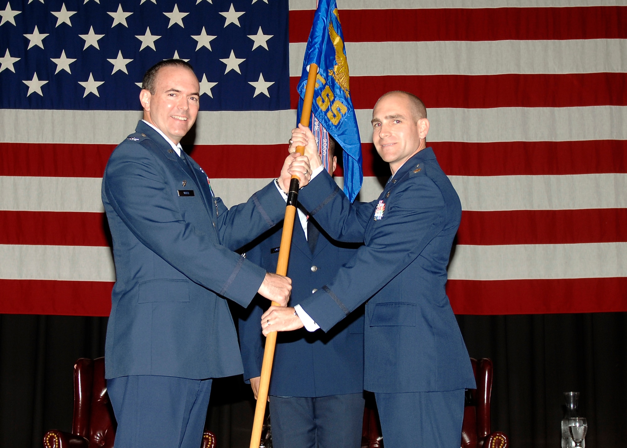 MCCONNELL AIR FORCE BASE, Kan. -- Col. Mark White, 22nd Mission Support Group commander, passes the guidon to Maj. Colin Huckins, incoming 22nd Force Support Squadron commander, during the Force Support Squadron Change of Command at the Dole Center ballroom, June 22. Major Huckins accepts the guidon to symbolize his assumption of command. (Photo by Senior Airman Anthony Mejia)