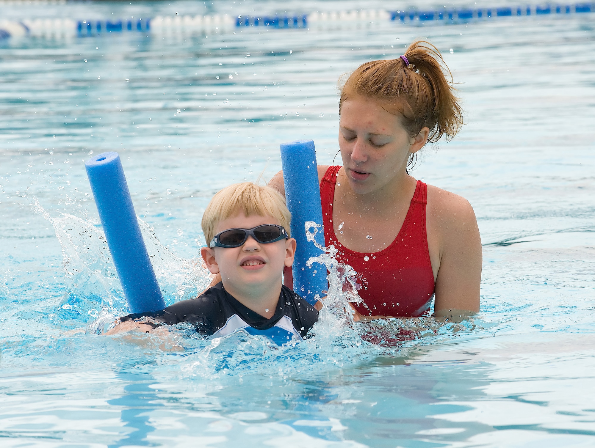 Malachi Liebl utilizes a flotation device as his swimming instructor, Emily Kolakowski, helps him practice proper ?dog paddle? techniques at the Oasis Pool at Dover Air Force Base June 23. Oasis Pool is the only pool at Dover Air Force Base, because the base pool has closed permanently due to construction for the new Fitness Center.  (U.S. Air Force photo/Tom Randle)