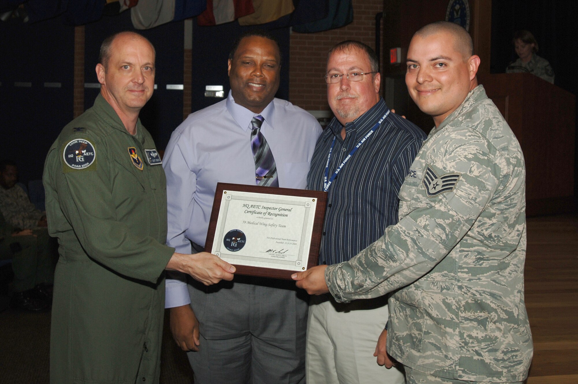 Col. Monty Brock, Air Education and Training Command Inspector General (left) presents Mr. Larry Cain, Mr. Michael Grriffith, and Staff Sgt. Victor Ramon, 59th Medical Wing Safety Team, a team excellence award for "outstanding" performance during the Unit Compliance Inspection June 23, Wilford Hall Medical Center, Lackland Air Force Base, Texas.  The 59th Medical Wing safety team was praised by Maj. Gen. Tom Travis, 59th Medical Wing Commander, for improving the safety program from an unsatisfactory rating three years ago to an outstanding rating during this UCI. (Air Force photo by Senior Airman Nicole Roberts)  