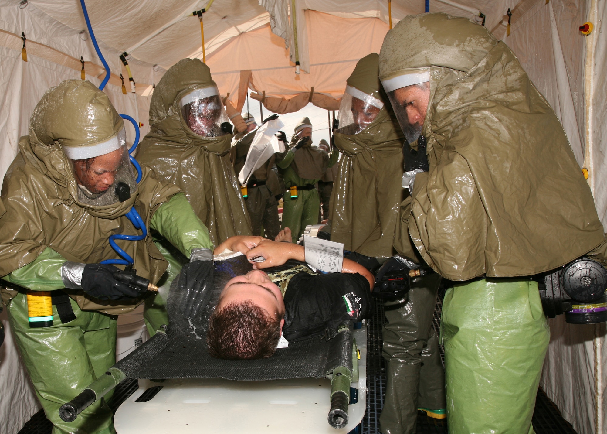 Members of the 59th Medical Wing decontamination team decontaminate a "victim" outside the Wilford Hall Medical Center Emergency Department during a mass casualty exercise June 16.  The exercise was part of the 59th MDW and 37th Training Wing Unit Compliance Inspection. (U.S. Air Force photo/Robbin Cresswell)