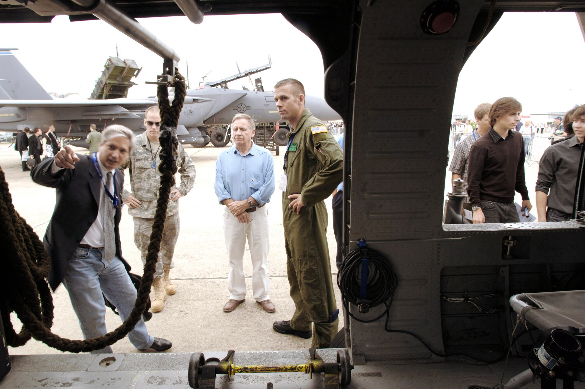 Aviation enthusiasts and French pilots Marc Heurtevant (left) and Michel Detre query Staff Sgt. Tyson Reams (right) and Staff Sgt. Matt Debertolis about the capabilities of the HH-60G Pave Hawk helicopter during the Paris Air Show June 18 at Le Bourget, France. Sergeant Reams is an HH-60G flight engineer and Sergeant Debertolis is a HH-60G crew chief. (Defense Department photo/Master Sgt. Scott Wagers) 
