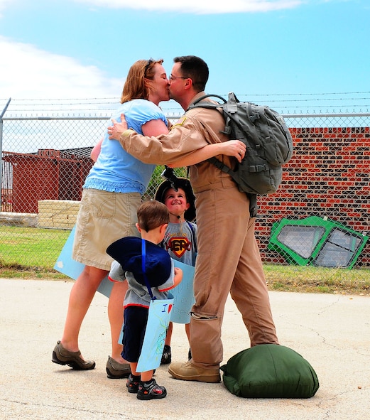 DYESS AIR FORCE BASE, Texas – Capt. Chad Bevan, 40th Airlift Squadron flight doctor, kisses his wife as his family welcomes him home from deployment June 21 here. More than 180 deployed Dyess Airmen returned from deployment after serving in Overseas Contingency Operations around the world.  (U.S. Air Force photo by Staff Sgt. Connor Estes)