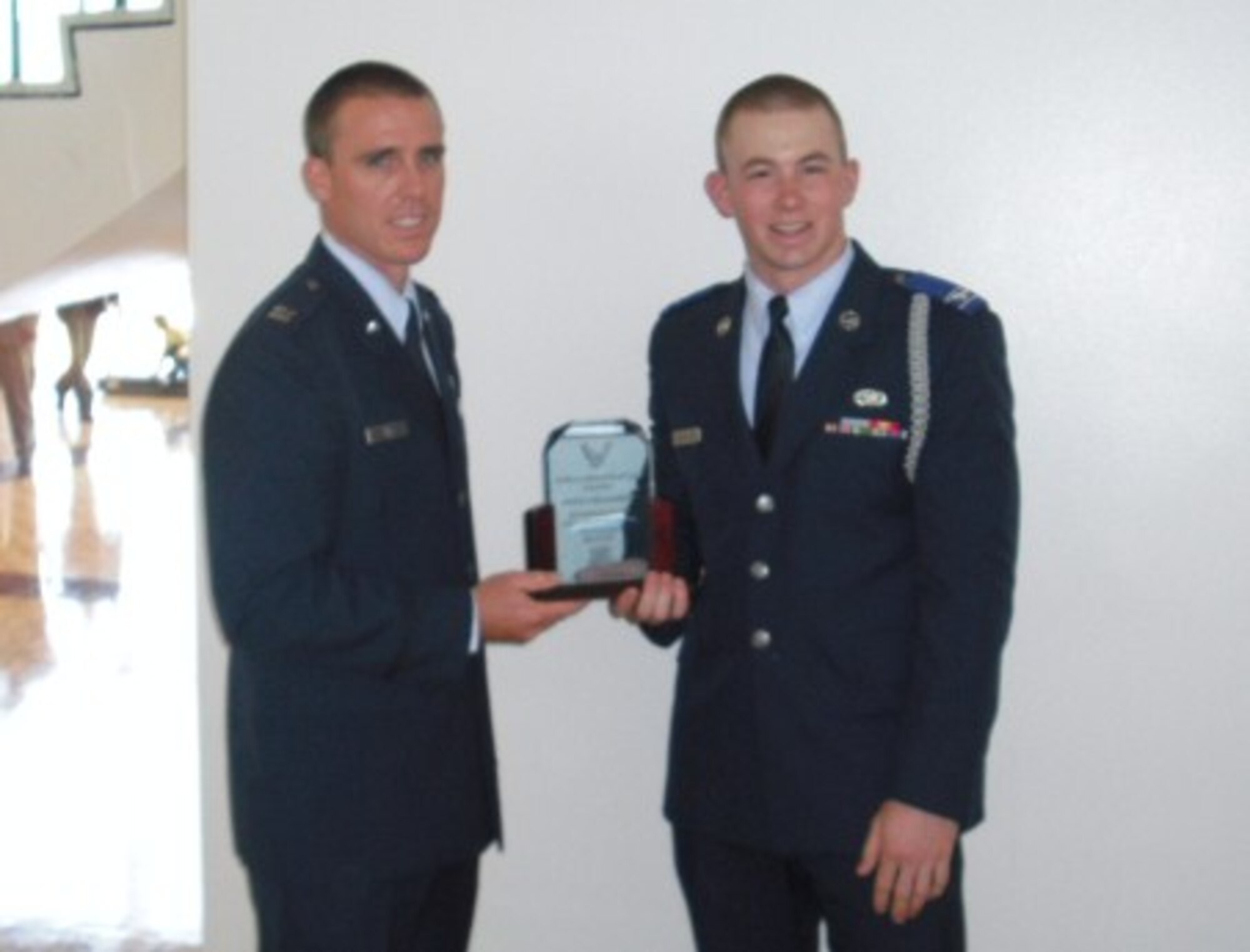 Capt. Ryan L. Avery, 944th Logistics Readiness Squadron fuels officer in charge, helps Cadet Andrew J. Kacura-Miller, a former 944th Logistics Readiness Squadron fuels technician, show off his award received for character development after his graduation from the Air Force Academy Preparatory School May 26.  With his successful completion of the preparatory school, Cadet Kacura-Miller now has the opportunity to continue on with his dream as he enters the U.S. Air Force Academy June 25 to begin basic cadet training the Class of 2013. 