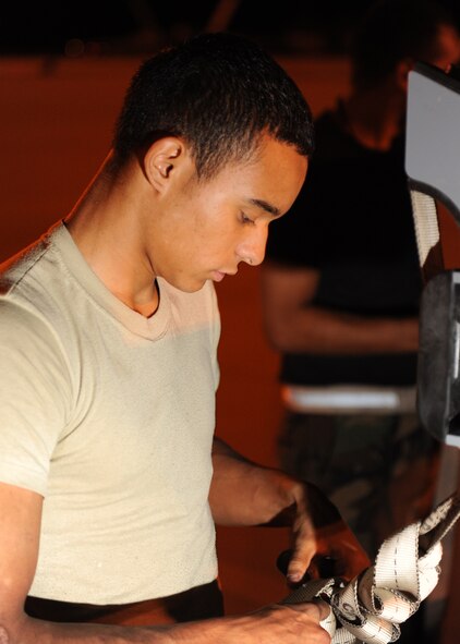 Airman 1st Class Andreous Madrid, 49th Aircraft Maintenance Squadron straps down a live  AIM-9 Sidewinder onto a bomb trailer to make sure they are safe and secure for transport, during the Weapons System Evaluation Program (WSEP), Holloman Air Force Base, N.M., June 24. Many Air Force fighter aircraft are participating in this evaluation. This is the first time F-22As from Holloman have been loaded with live munitions. (U.S. Air Force photo/Senior Airman Michael Means)