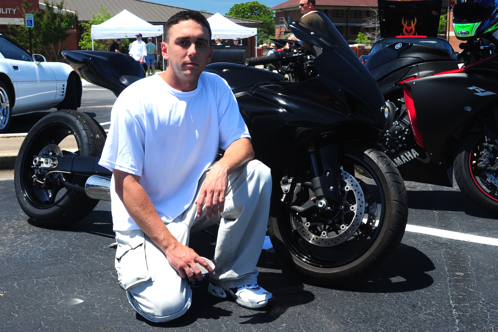 Staff Sgt. Tyler Ludwick, 19th Component Maintenance Squadron unit fitness program manager, poses with his 2006 GSxR 1000 Suzuki motorcycle at the Little Rock Air Force Base Car and Bike Show Friday. Airmen from all across the base came together to view the cars and motorcycles on display in the Hercules Dining Facility Parking lot. (U.S. Air Force photo by Senior Airman Steele Britton)