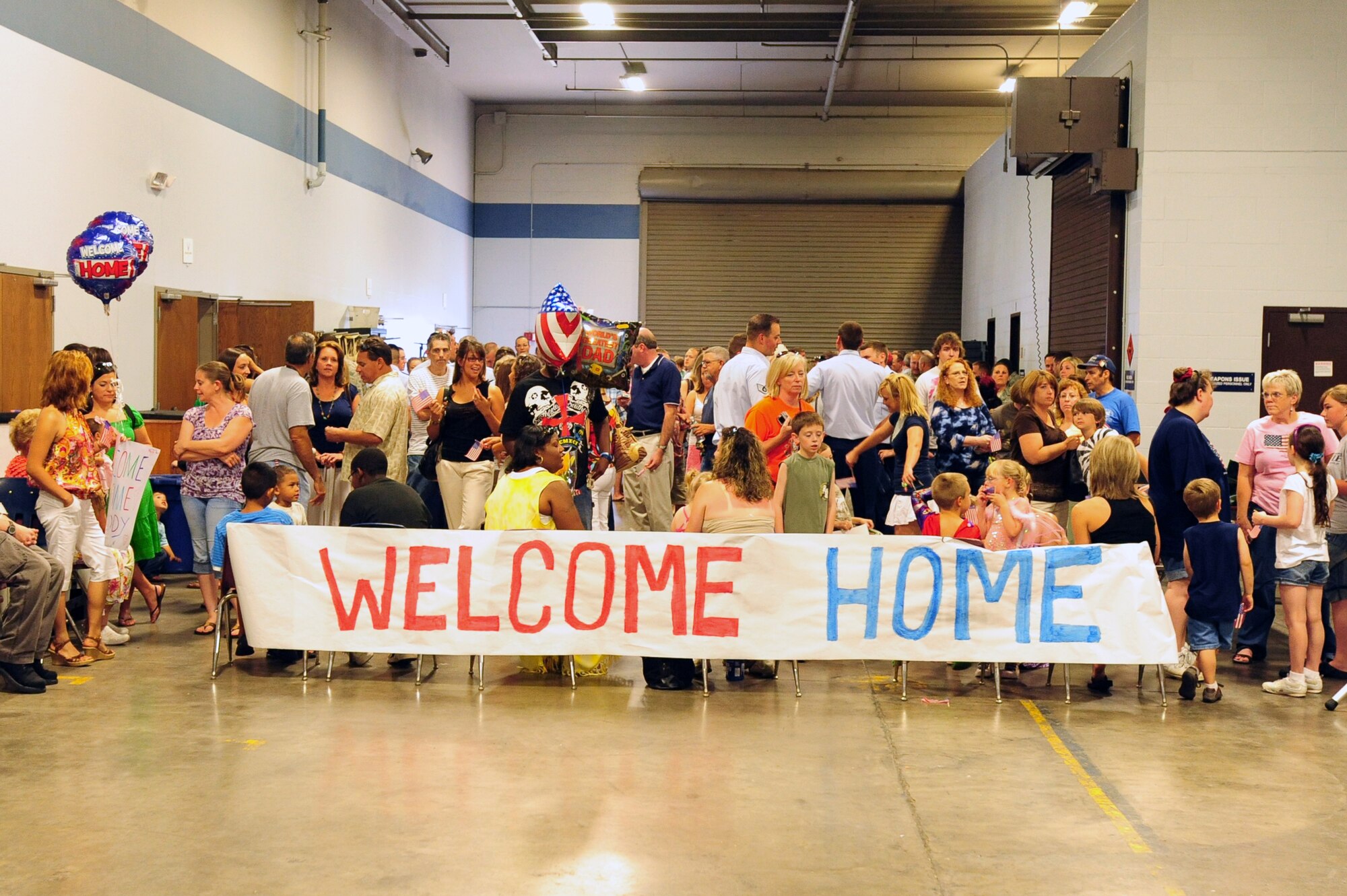 Families wait to lovingly welcome deployers home at bldg. 430 Monday. Families and base leadership came together to greet returning Airmen and show appreciation for their sacrifice. (U.S. Air Force photo by Senior Airman Steele Britton)