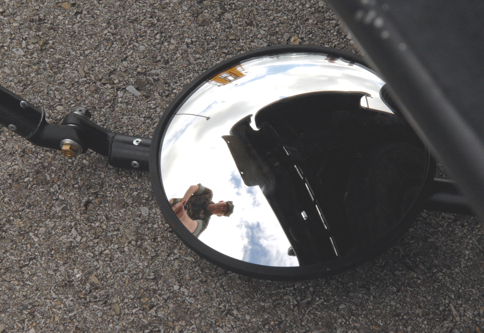 WHITEMAN AIR FORCE BASE, Mo. - Storekeeper 2nd Class Jeff Shaver, Maritime Expeditionary Security Division 13, utilizes a vehicle search mirror during vehicle search training on the June 13-14 drill weekend.  MESD 13 supports the Navy Expeditionary Combat Command’s mission of providing security for inshore water resources.  (U.S. Air Force photo/Master Sgt. Stan Coleman)