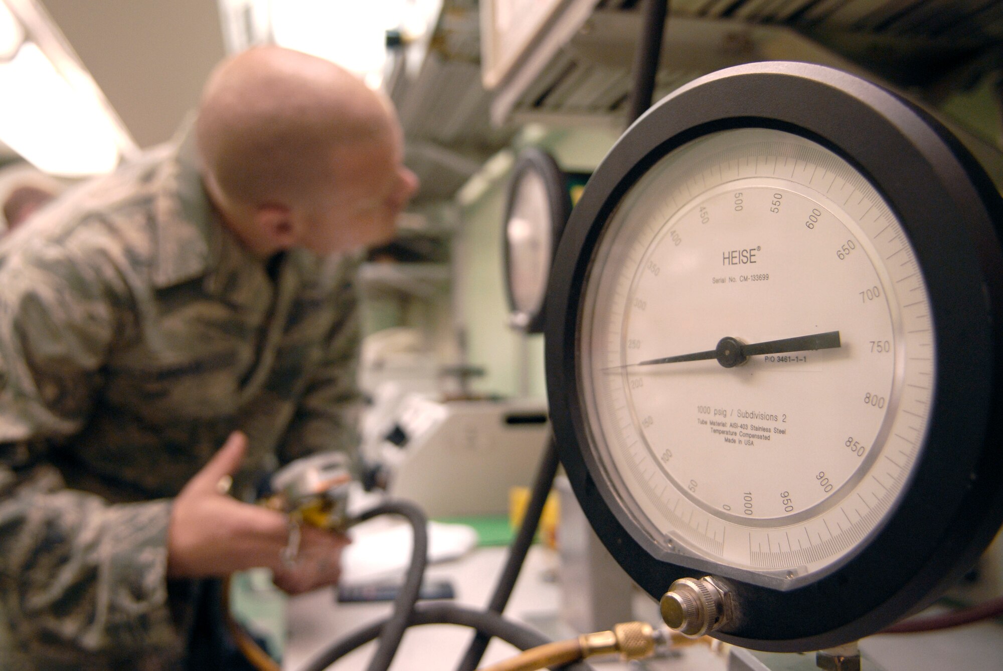 Staff Sgt. Mason Lucas uses a pressure gauge to check a tire inflator's relief valve June 15 at an air base in Southwest Asia. The tire inflator will be used in a forward operating location in the U.S. Central Command's area of responsibility. The Airmen who work in the Precision Measurement Equipment Laboratory calibrate and test equipment critical to mission accomplishment. Sergeant Lucas is a 379th Expeditionary Maintenance Squadron test measurement diagnostic equipment craftsman. He is a native of Purcellville, Va., and is deployed from Langley Air Force Base, Va. (U.S. Air Force photo/Senior Airman Andrew Satran) 
