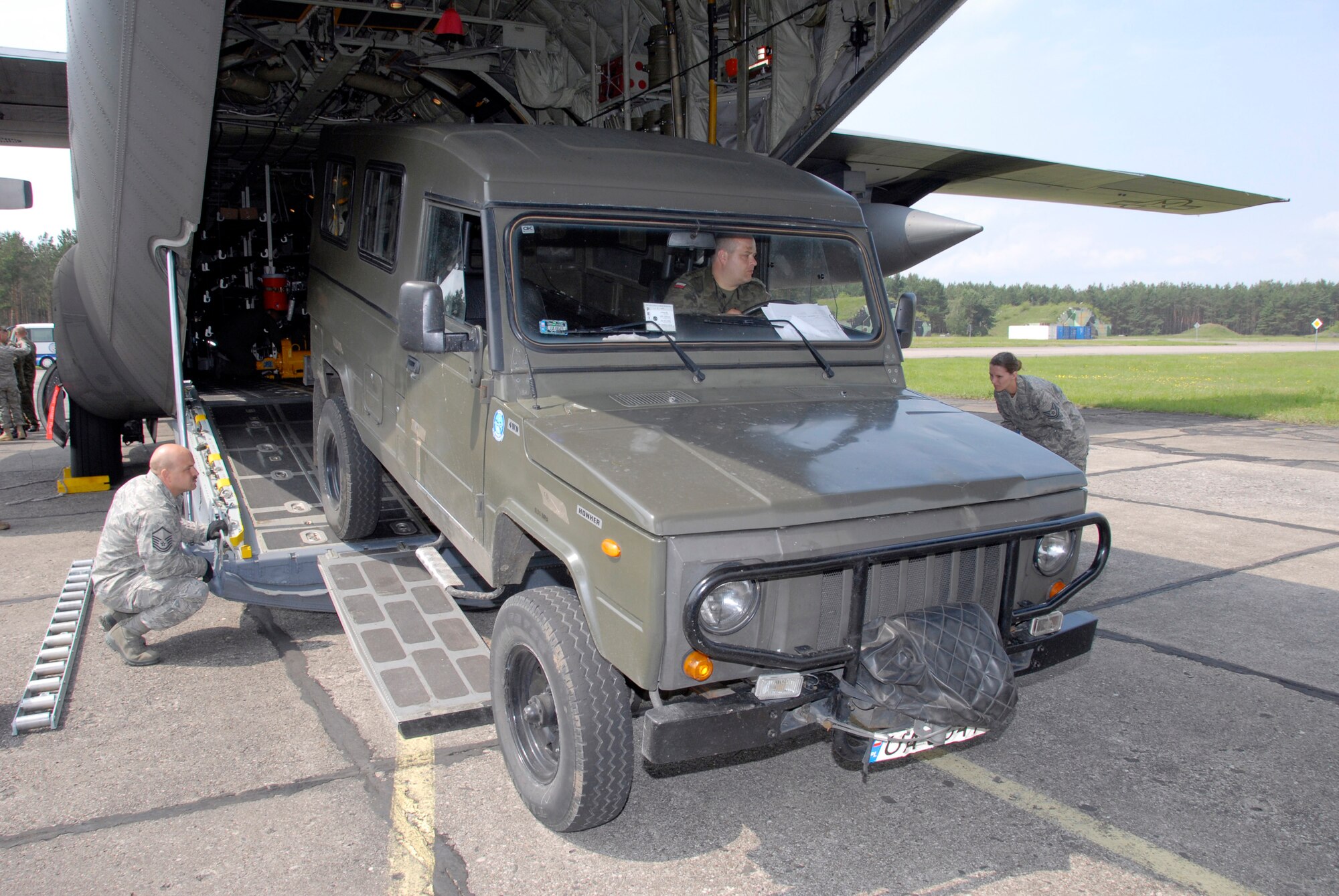 Chief Master Sgt. Rick Barnick discusses options as he and his Polish counterparts prepare to winch a Polish all-terrain vehicle onto a C-130 Hercules June 19 at Powidz, Poland. The 182nd Airlift Wing is in Poland as part of the Illinois Air National Guard's Partnership with the Polish air force under the State Partnership Program. Chief Barnick is the 169th Airlift Squadron chief loadmaster. (U.S. Air Force photo/Tech. Sgt. Shane Hill) 
