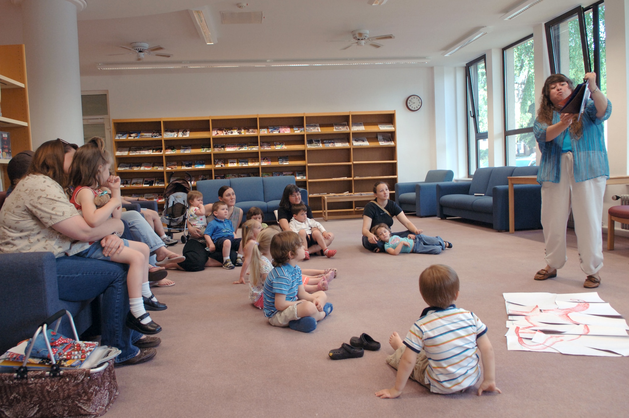 Debbie Worthington (right), 435th Services Squadron library programs technician, reads to children at the library about dinosaurs, June 18, 2009, Ramstein Air Base, Germany. Along with stories, children also participated in a dinosaur hunt and a dinosaur stomp song as part of the summer reading program. (U.S. Air Force photo by Senior Airman Amanda Dick)