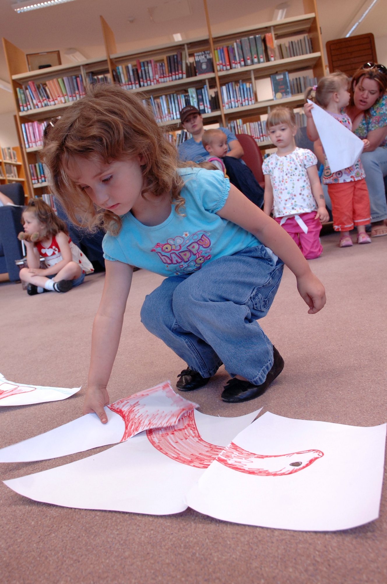Kaitlin Blakeman, daughter of U.S. Air Force Staff Sgt. James Blakeman, 721st Aircraft Maintenance Squadron, adds her piece of the puzzle to create a dinosaur at the library, June 18, 2009, Ramstein Air Base, Germany. Kaitlin Blakeman, along with other children, pretended to be paleontologists by putting pieces of a dinosaur together to figure out what kind of dinosaur they had discovered, during story time as part of the summer reading program. (U.S. Air Force photo by Senior Airman Amanda Dick)