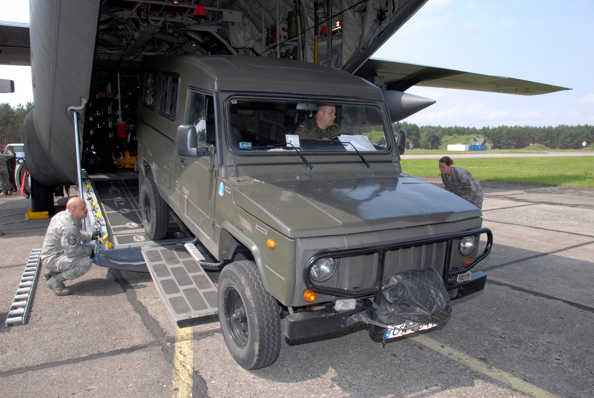 Chief Master Sgt. Rick Barnick, 169th Airlift Squadron Chief Loadmaster,
discusses options he uses when wenching vehicles as he and his Polish
counterparts as they prepare to wench a Polish 'Honker' all terrain vehicle
on to a 182nd Airlift Wing C-130. The 182nd Airlift Wing is in Poland as
part of the Illinois Air National Guards Partnership with the Polish Air
Force under the State Partnership Program. (U.S. Air Force photo/Tech. Sgt. Shane Hill)