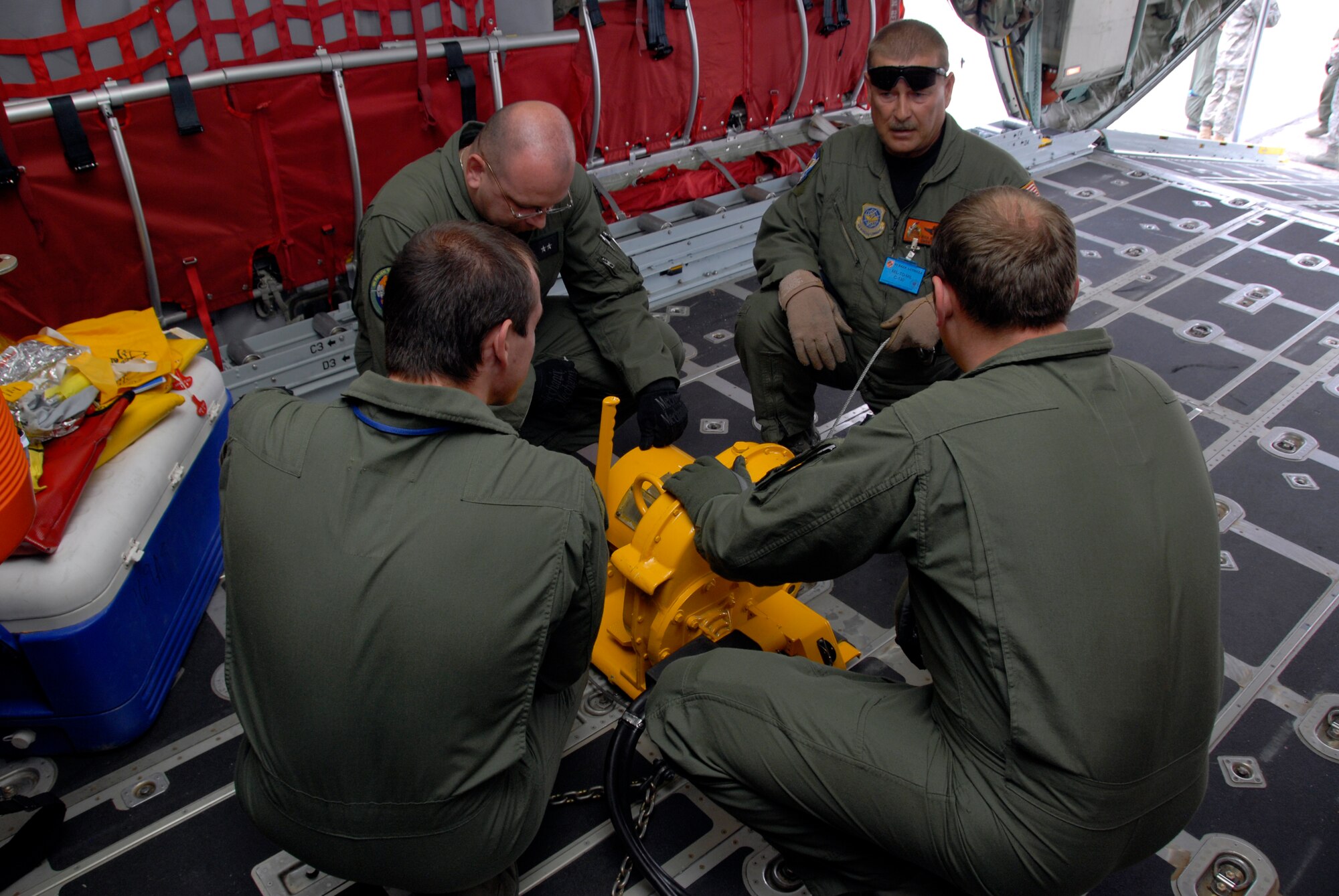 Chief Master Sgt. Rick Barnick, 169th Airlift Squadron Chief Loadmaster,
assists his Polish counterparts as they prepare to wench a Polish 'Honker'
all terrain vehicle, while onboard a 182nd Airlift Wing C-130. The 182nd
Airlift Wing is in Poland as part of the Illinois Air National Guards
Partnership with the Polish Air Force under the State Partnership Program. (U.S. Air Force photo/Tech. Sgt. Shane Hill)