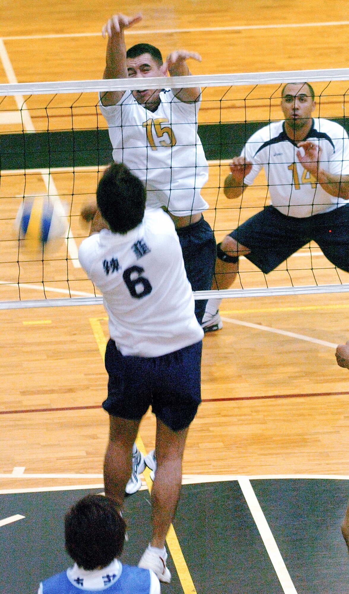 YOKOTA AIR BASE, Japan -- James Dela-Pena (No. 15) roofs a member of the Japanese squad Rakkyo June 21 during the championship match of the Kanto Volleyball Invitational Tournament at the Samurai Fitness Center here. The Yokota Warriors won the mens' division of the tournament with a straight-set victory over Rakkyo. The Yokota Warriors womens' team took second, losing in the finale to Link, a local Japanese squad. (U.S. Air Force photo/Master Sgt. Matt Summers)   
