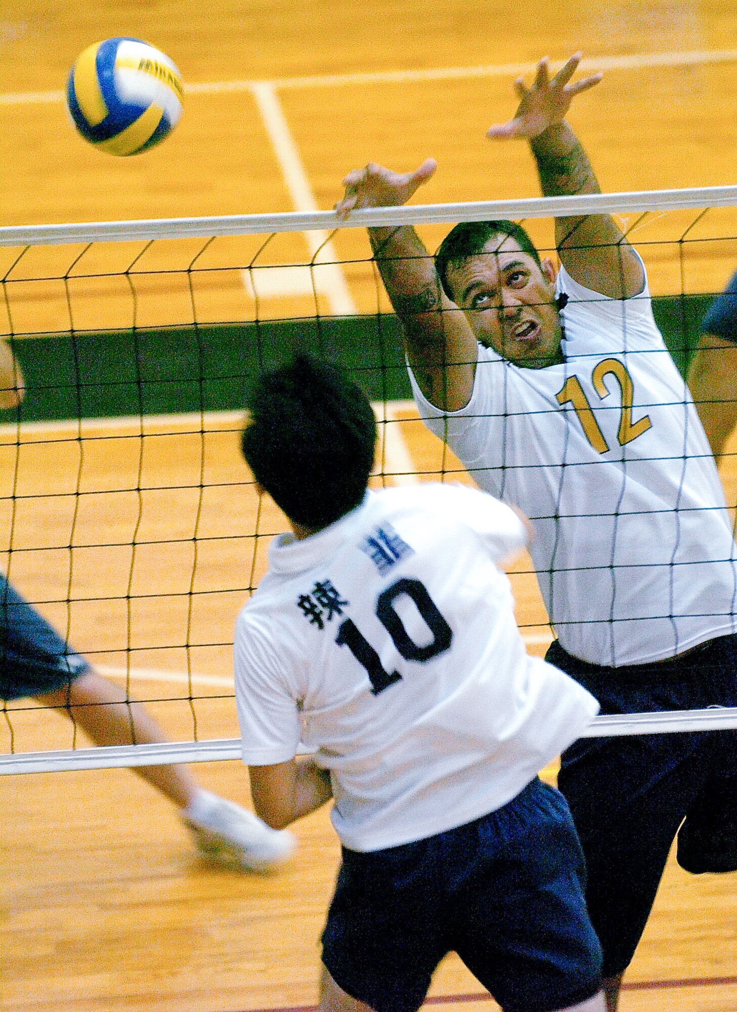 YOKOTA AIR BASE, Japan -- Elisha Timoteo (No. 12) tries a single block against a member of the Japanese squad Rakkyo June 21 during the championship match of the Kanto Volleyball Invitational Tournament at the Samurai Fitness Center here. The Yokota Warriors won the mens' division of the tournament with a straight-set victory over Rakkyo. The Yokota Warriors womens' team took second, losing in the final to Link, a local Japanese squad. (U.S. Air Force photo/Master Sgt. Matt Summers)   