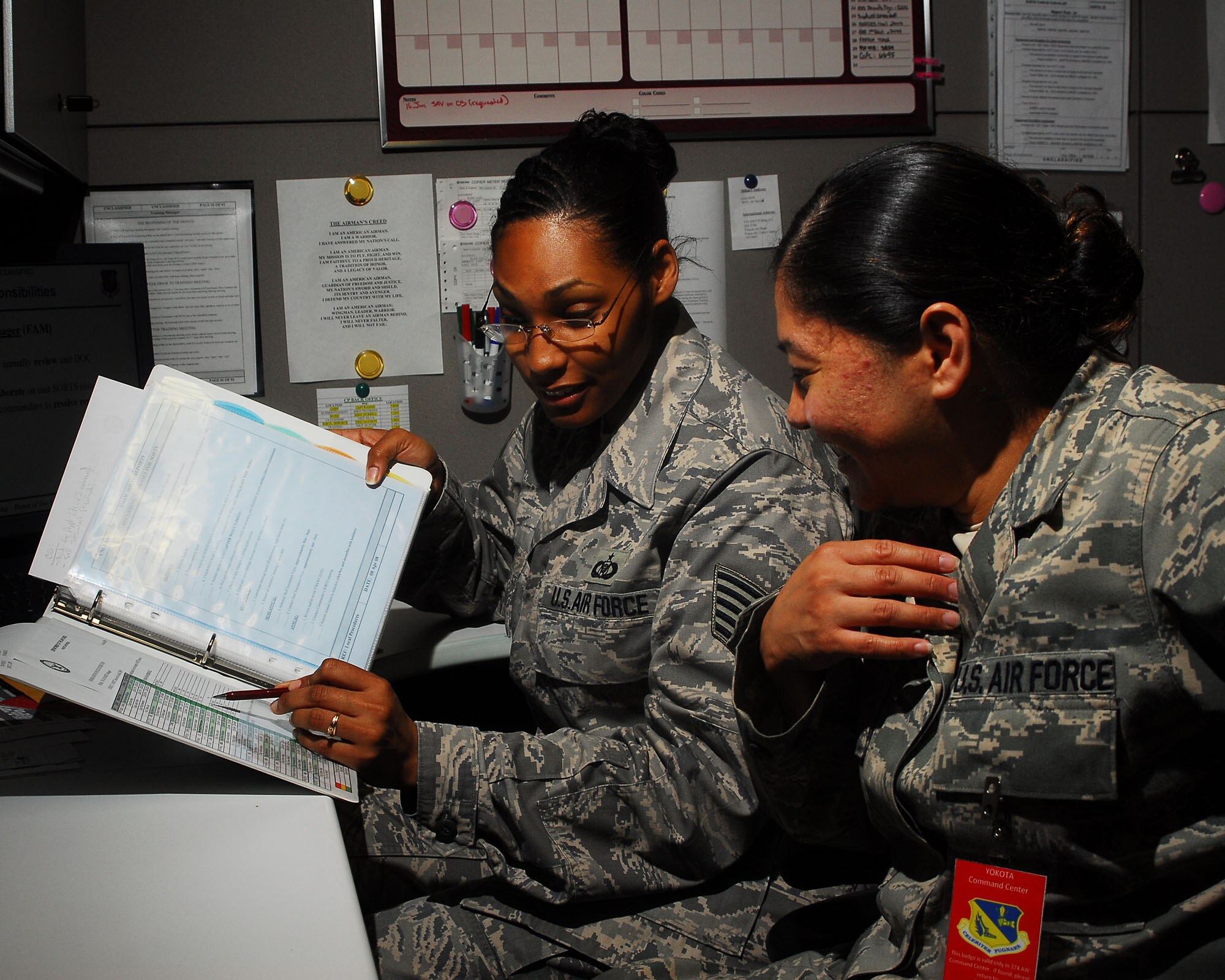 YOKOTA AIR BASE, Japan -- Tech. Sgt. Rachel Hunter, 374th Airlift Wing Command Post, trains Staff Sgt. Torie Hawkins, 374th Operations Support Squadron, June 24 on status of resources .  The command post receives and relays command and control instructions and records, and submits manual and automated data projects. (U.S. Air Force photo/Airman 1st Class Sean Martin)