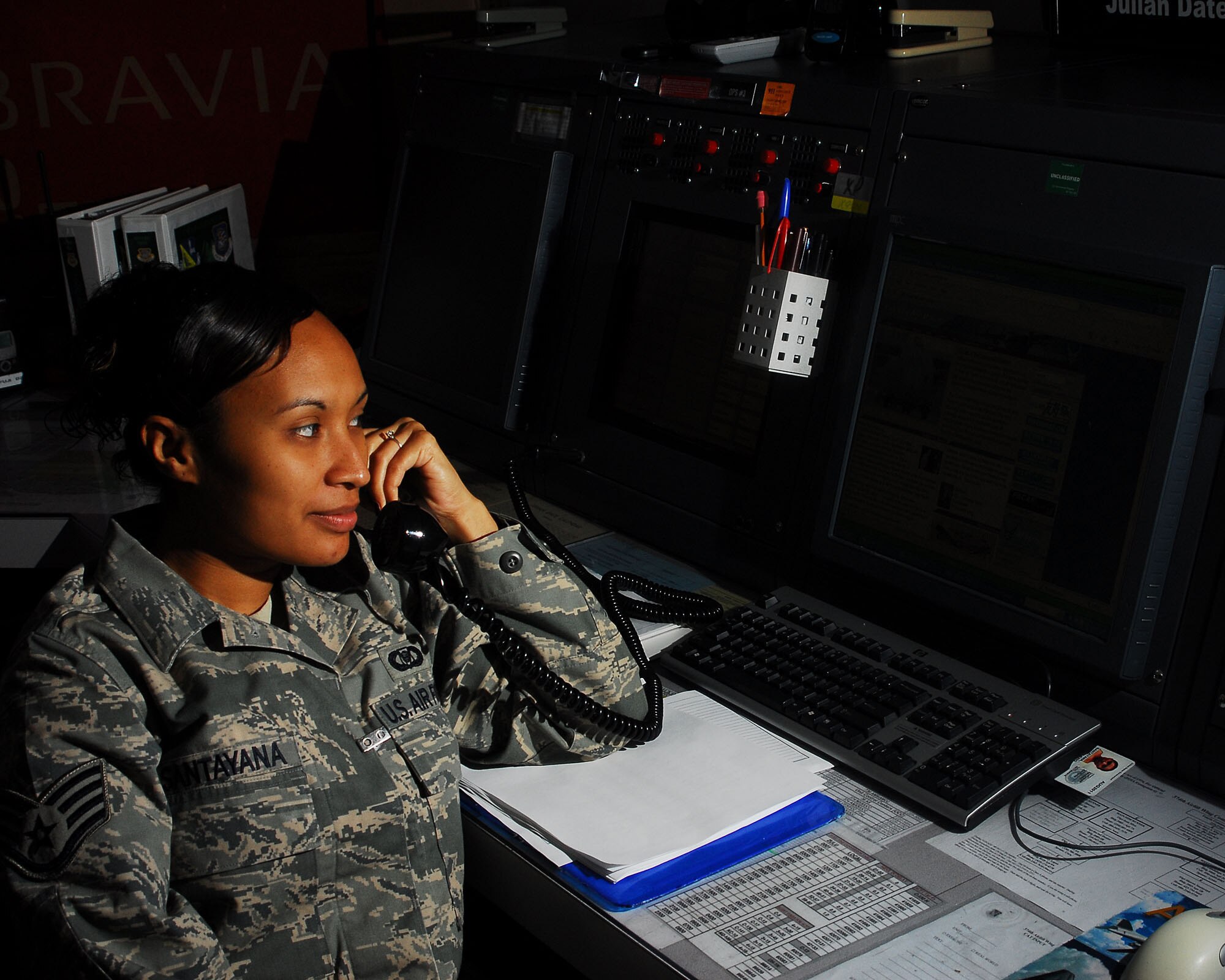 YOKOTA AIR BASE, Japan -- Staff Sgt. Sharon Santayana, 374th Airlift Wing Command Post emergency actions controller, contacts essential agencies to provide emergency action notifications June 24. The command post receives and relays command and control instructions and records, and submits manual and automated data projects. (U.S. Air Force photo/Airman 1st Class Sean Martin)