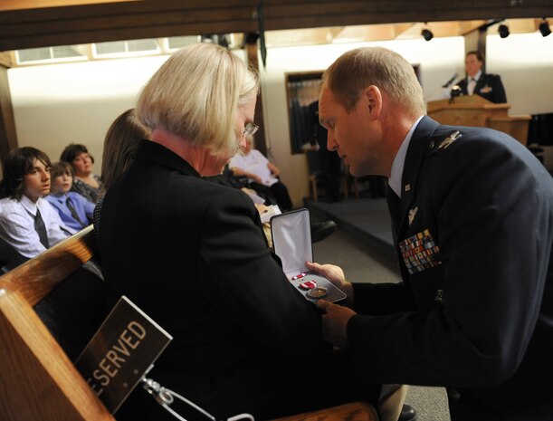 Col. Christian Benjamin, 99th Medical Group commander, presents the Meritorious Service Medal to Mrs. Lisa Prager, wife of Lt. Col. H. Robert Prager, during a special memorial ceremony honoring Lt. Col. Prager at the base chapel, Nellis Air Force Base, Nev., June 23. Lt. Col. Prager was a flight surgeon assigned to the 99th Medical Group and was laid to rest with full military honors.(U.S. Air Force Photo/Senior Airman Larry E. Reid Jr.)