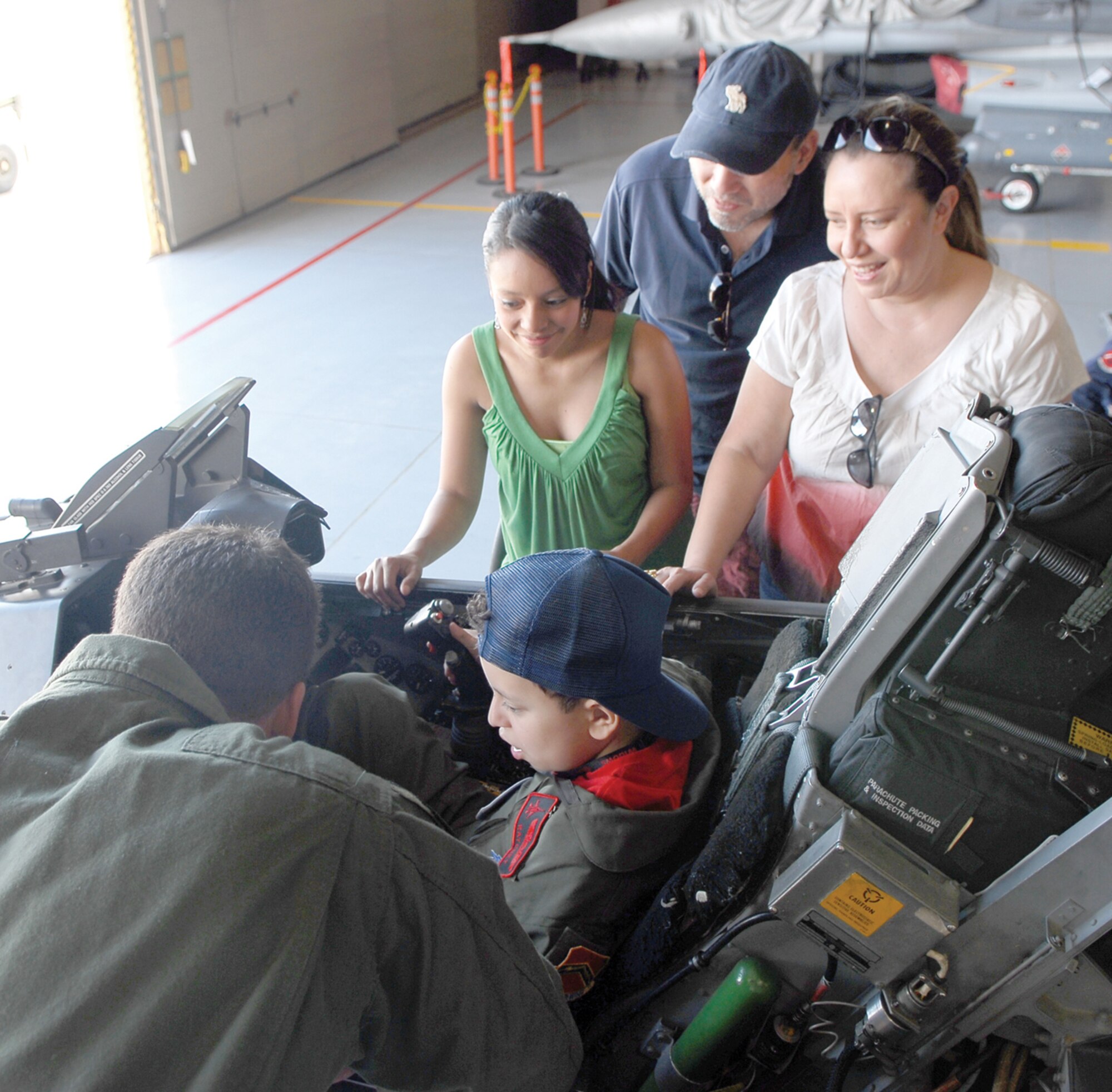 Maj. Nathan Litz, left, 425th Fighter Squadron project officer, shows pilot-for-a-day “Ratchet” and his family the cockpit of an F-16 during his visit to Luke. Accompanying Rafael are his father, Rafael; his mother, Doris; and his sister, Gerardina. (U.S. Air Force photo/ Airman 1st Class Ronifel Yasay)