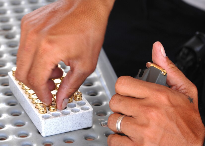 A member of the 56th Security Forces Squadron loads 9mm ammo into a clip before a day of training at the Glendale Training Center Range. (U.S. Air Force photo/ Tech. Sgt. Jeffery Wolfe)