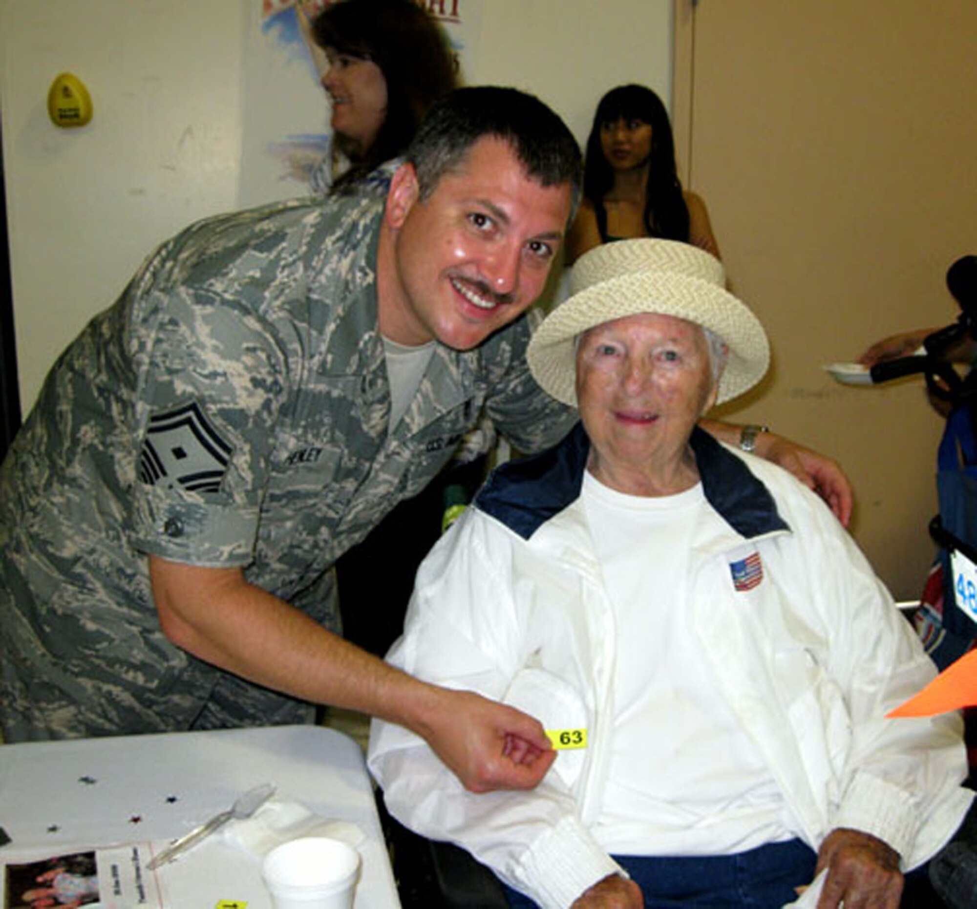 TRAVIS AIR FORCE BASE, Calif. -- A resident of the California Veterans Home, Yountville, waits for her raffle number to be called during Operation Gratitude June 20, 2009. Assisting her is Senior Master Sgt. Jim Henley, first sergeant, 349th Mission Support Squadron. A large group of reservists from the 349th Air Mobility Wing set up and serve a yearly champagne brunch to the veterans to show appreciation for their service to America. Read the full story in the August issue of the Contact magazine. (U.S. Air Force photo/Senior Master Sgt. Ellen Hatfield)