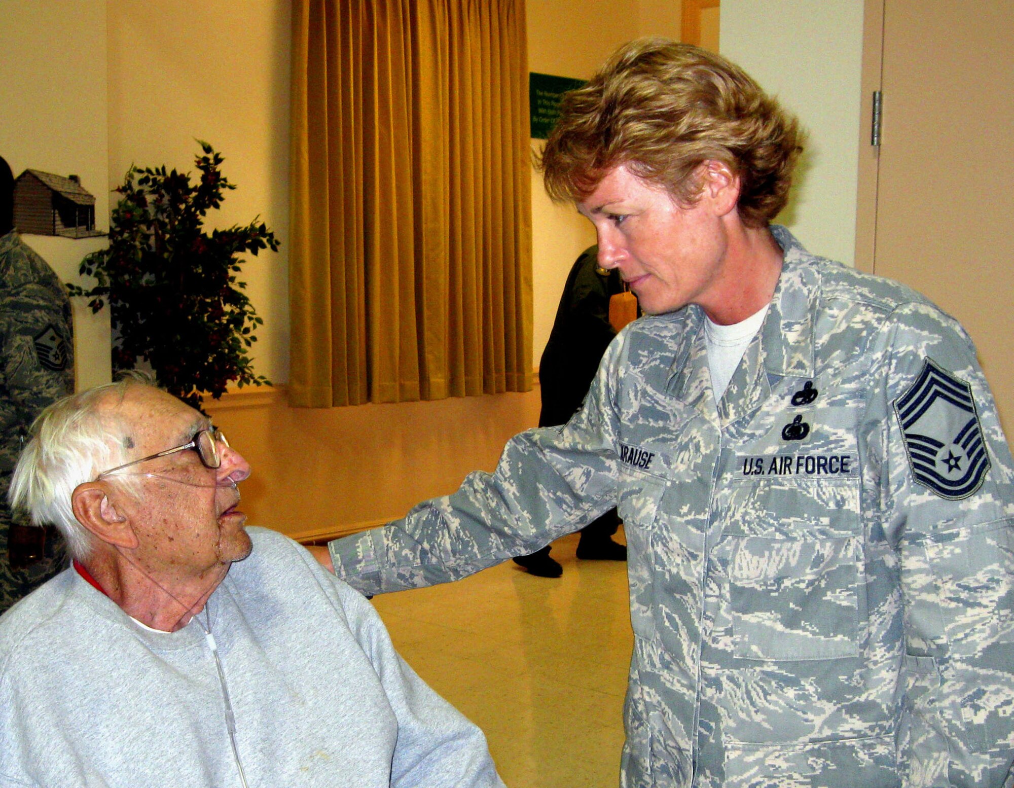 TRAVIS AIR FORCE BASE, Calif. -- Chief Master Sgt. Karen Krause chats with a resident of the California Veterans Home, Yountville, June 20, 2009. The Chief joined a large group of reservists from the 349th Air Mobility Wing who visit the veterans yearly during Operation Gratitude. The Air Force reservists set up and serve a champagne brunch to the veterans as their way of saying "Thank you for your service to America." Read the full story in the August issue of the Contact magazine. (U.S. Air Force photo/Senior Master Sgt. Ellen Hatfield) 