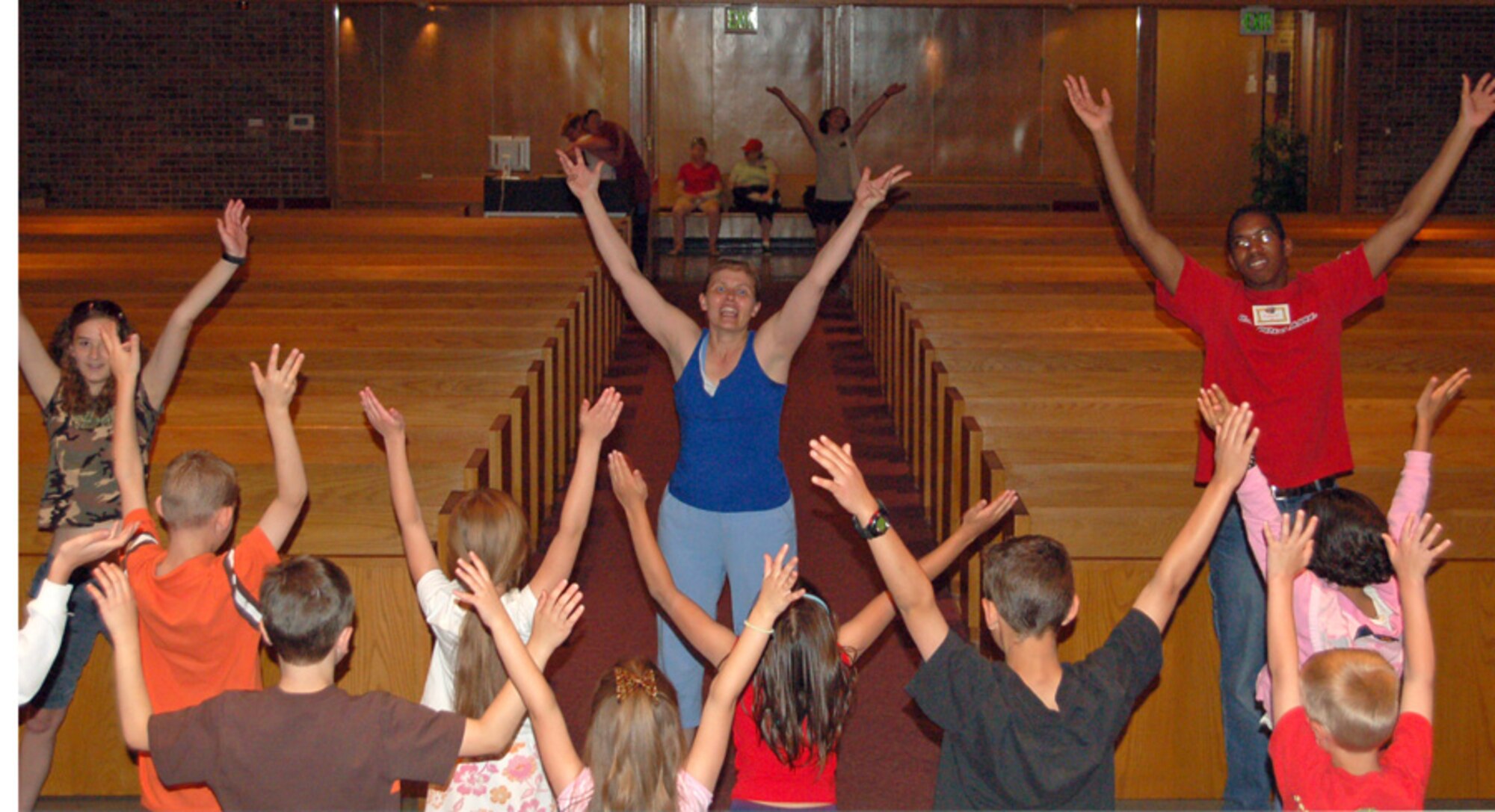 Volunteers Faith Glidewell, Diane Martain and Kameron Baker teach children a dance during the Vacation Bible SchoolTruth Trek "Digging Up God's Treasures" activities at the Peterson Chapel June 17. (Air Forcer photo by Thea Skinner) 