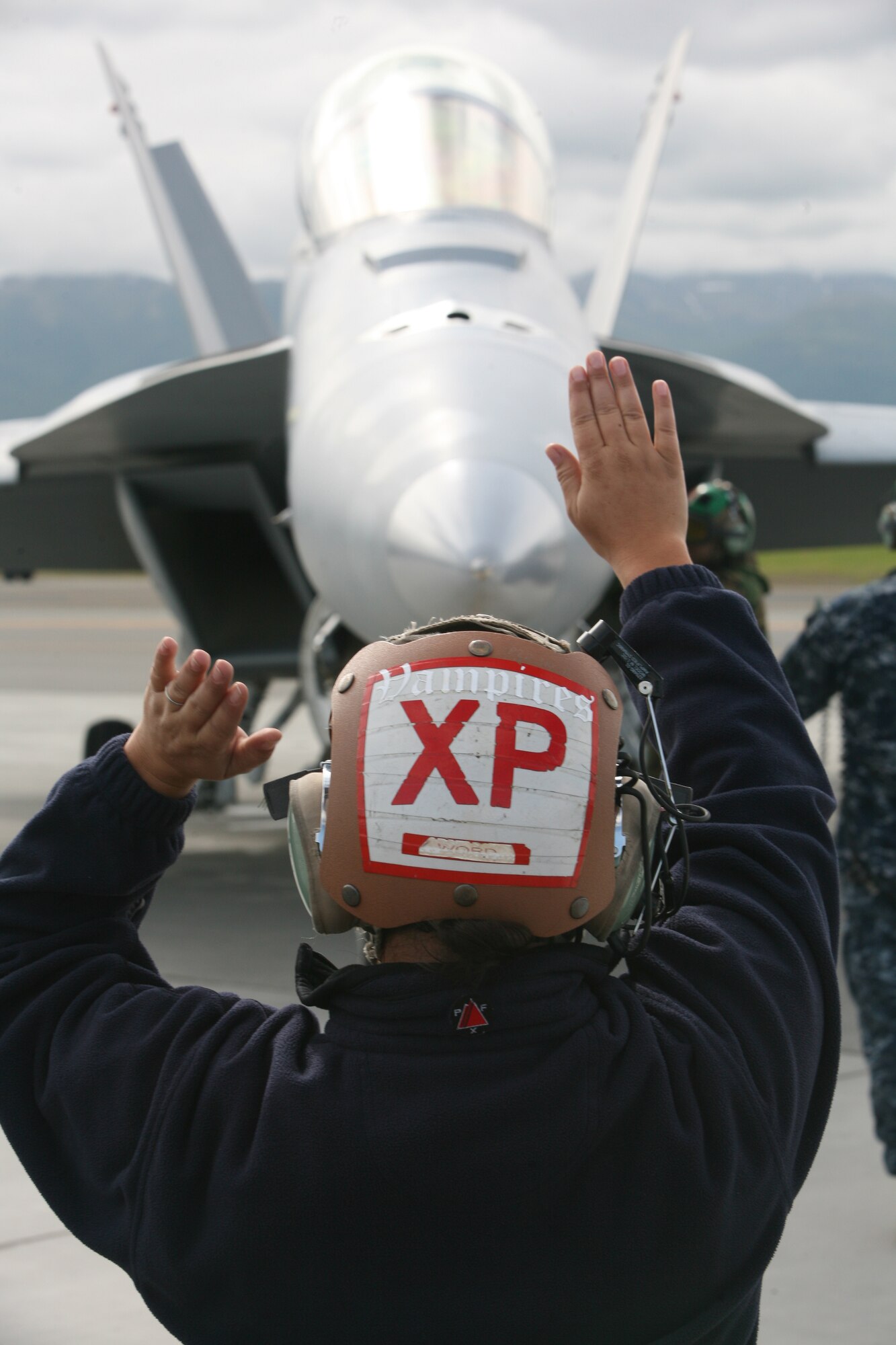 ELMENDORF AIR FORCE BASE, Alaska -- Deanna Word, a civilian plane captain with Navy Air Test and Evaluation Squadron 9, signals the pilot of a F/A-18F Super Hornet to move the flaps of the aircraft before it takes off from the flightline here June 19. (U.S. Air Force photo/Marine Corps Sgt. Zachary Dyer)