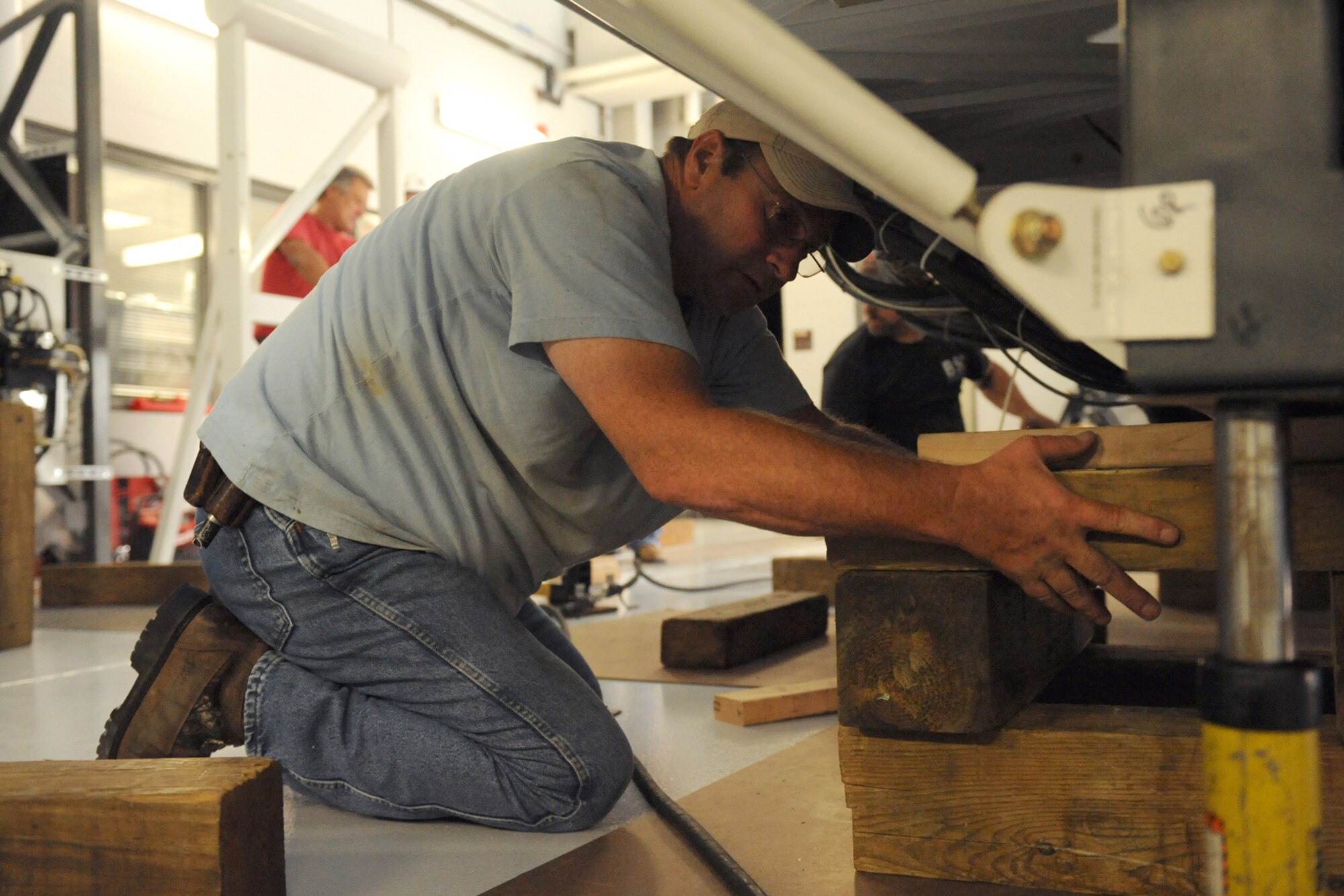 David Bronson, mechanic for Binghamton Simulator Company, places blocks under the KC-135R flight simulator near the flightline on Seymour Johnson Air Force Base, N.C., June 24, 2009. The blocks lift the simulator so hydraulic jacks can be placed underneath. (U.S. Air Force photo by Airman 1st Class Whitney S. Lambert)
