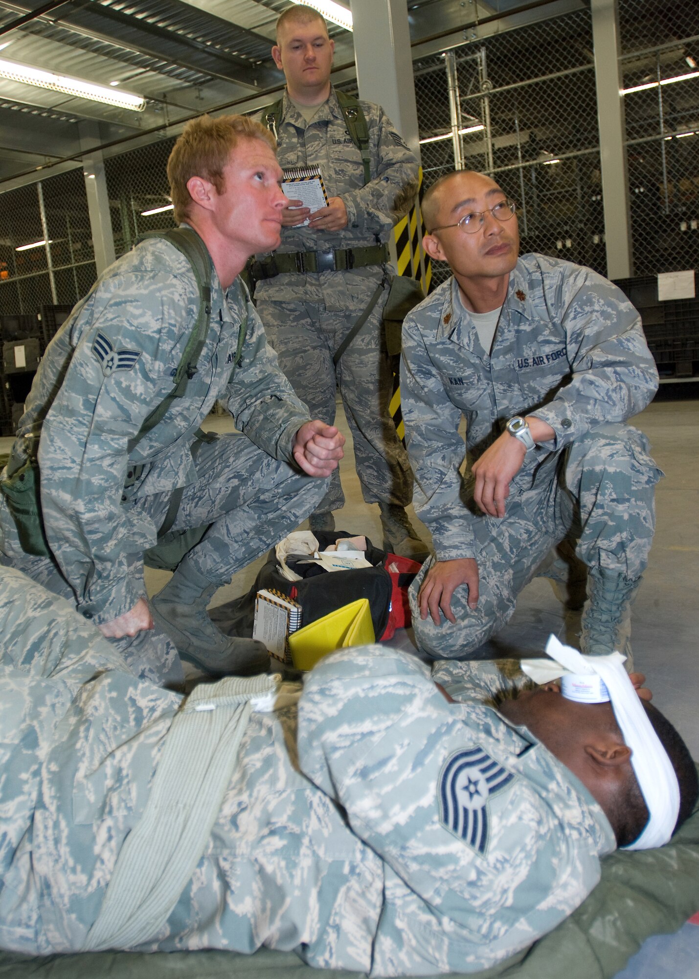 Airmen treat a simulated eye wound during phase two of Edwards operational readiness exercise June 24. Phase two of the exercise, Airmen received training on weapons familiarization, CBRN, self-aid buddy care and explosive ordnance sweeps. (Air Force photo/Heather Anhalt)