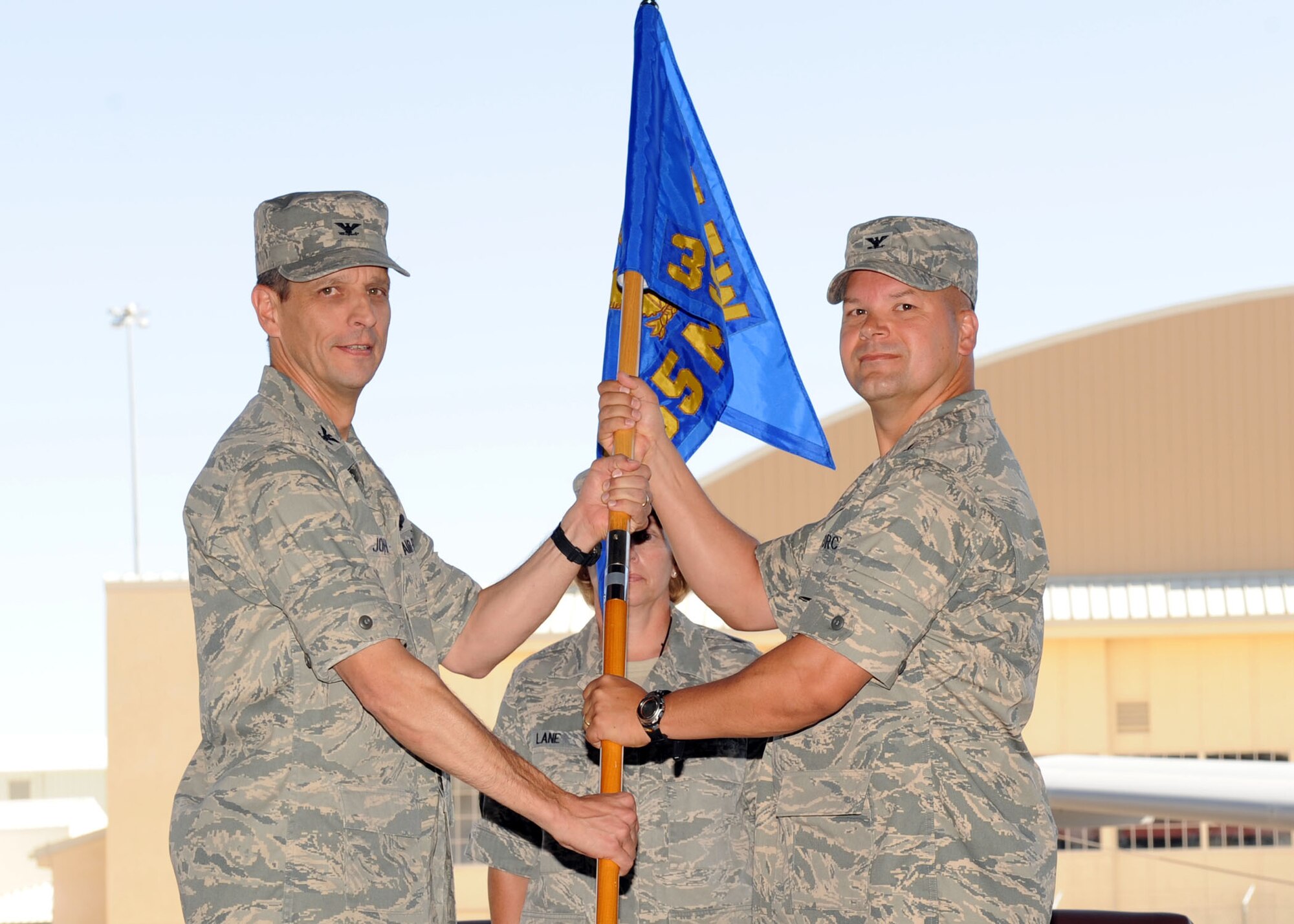 Col. Peter Hofelich receives the 355th Maintenance Group guidon from Col. Paul Johnson, 355th Fighter Wing Commander during the change-of-command ceremony at the Phase Hanger here June 22. Colonel Hofelich assumed command of the 355th MXG from Col. Dennis Shumaker. (U.S. Air Force photo by Airman 1st Class Brittany Dowdle) 