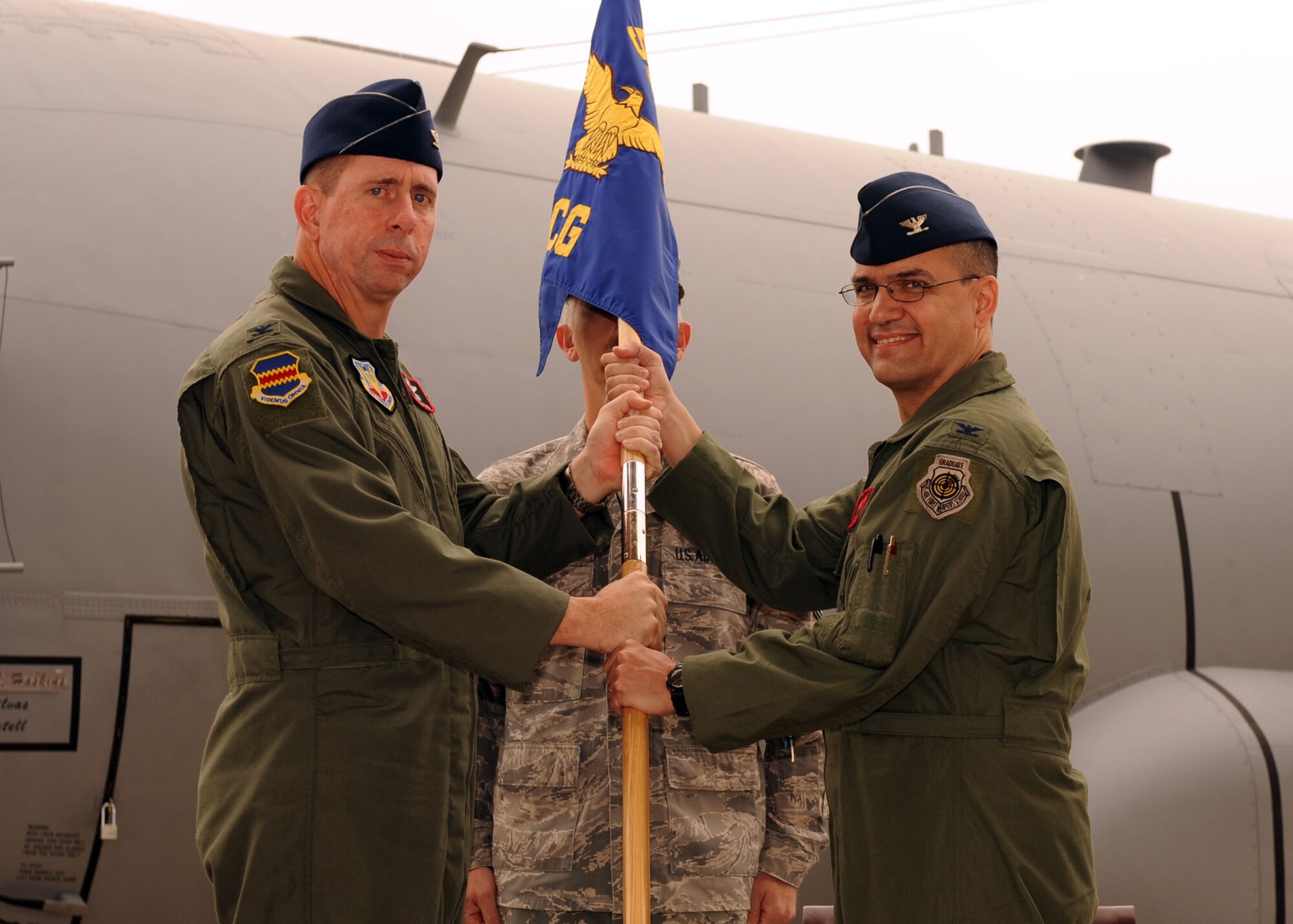 Col. Larry Worley receives the 55th Electronic Combat Group guidon from Col. John Shanahan, 55th Wing commander during a change-of-command ceremony at Whiskey Ramp here June 19. Colonel Worley assumed command of the 55th ECG from Col. Mark Haskins. (U.S. Air Force photo by Airman 1st Class Brittany Dowdle) 