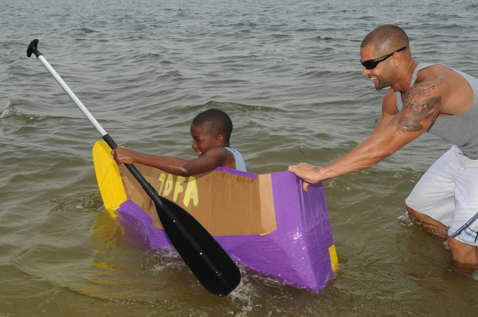 Drug Education For Youth  Program (DEFY) campers build a boat using only cardboard, duct tape, and paint during the DEFY Boat regatta on June 10 2009. Campers have two ways to win the regatta either have the fastest boat or the longest floating boat.  (U.S. Air Force photographer Senior Airman David Minor)