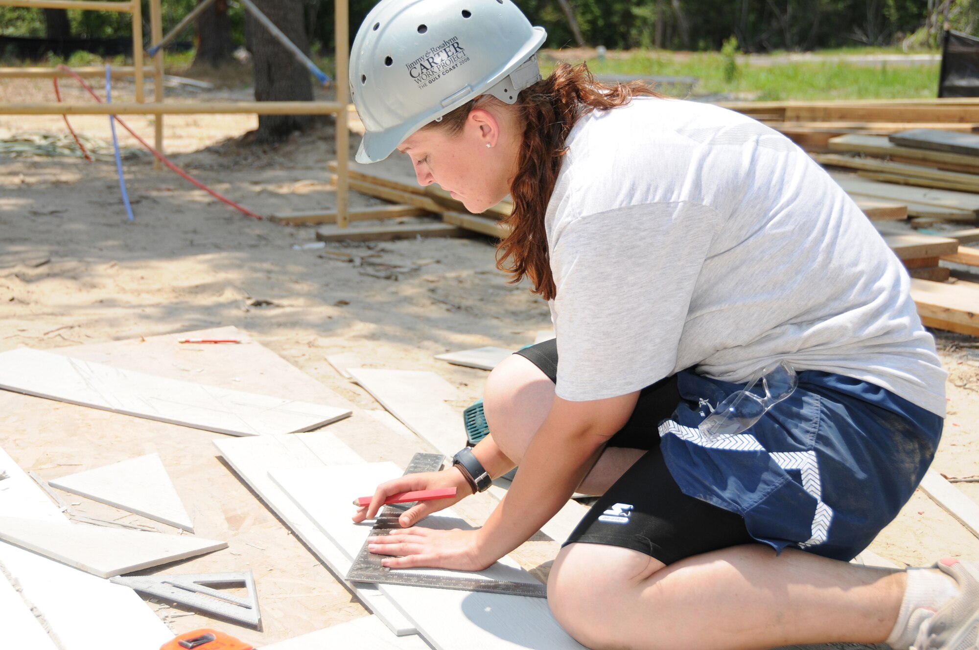 Airman Tanya Shaw measures and cuts exterior siding for the house.  Both are students from the 332nd Training Squadron team that worked on the project Saturday.  (U.S. Air Force photo by Kemberly Groue)