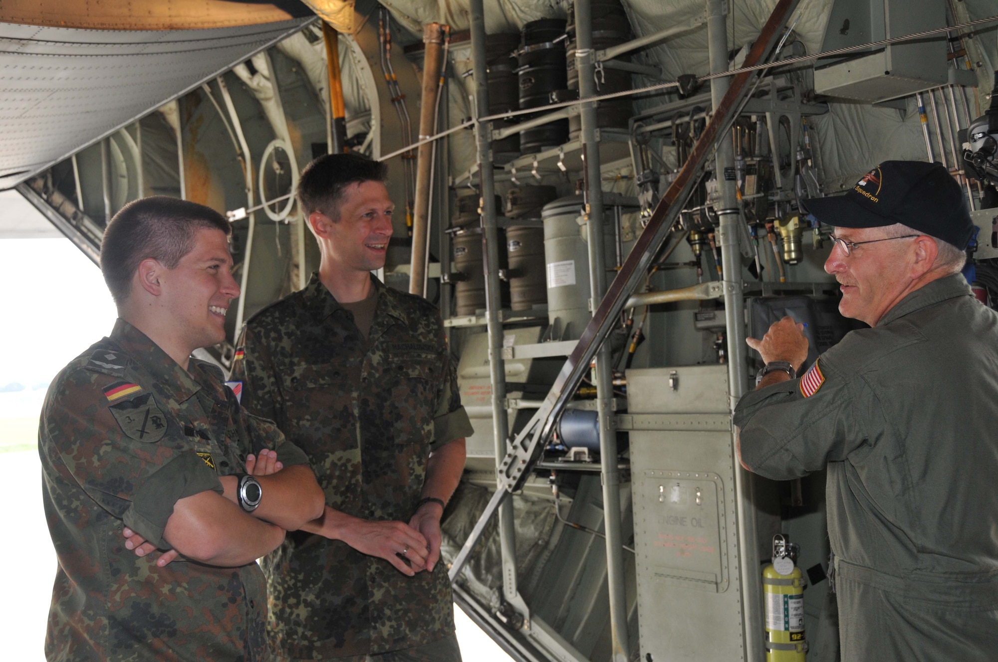 Master Sgt. Gary Scheff, 27th Aerial Port Squadron, talks about the features of the C-130 aircraft with German Air Force Reserve officers Capts. Axel Schmidt (left) and Ilja Machalowsky.  The officers are part of an exchange program which allows U.S. and foreign officers to experience similar duty functions with the services of other countries. (Air Force Photo/Master Sgt. Kerry Bartlett) 
