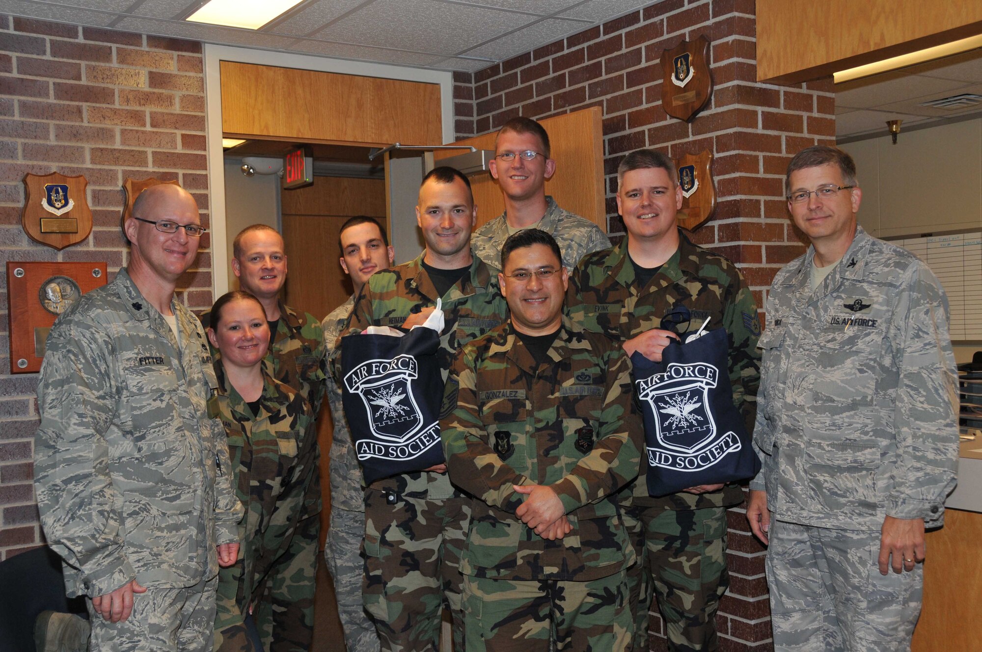 Senior Airman Matthew Heiman (left) and Staff Sgt. Darrin Evink, 934th Civil Engineer Squadron, display their baby bundles which are given to new Air Force parents by the Air Force Association. The bundles were presented by Col. Tim Tarchick, 934th Airlift Wing commander, (far right) and Lt. Col. John Fitter, 934th Civil Engineer Squadron commander, as fellow CE members were on hand to offer congratulations. (Air Force Photo/Master Sgt. Kerry Bartlett)