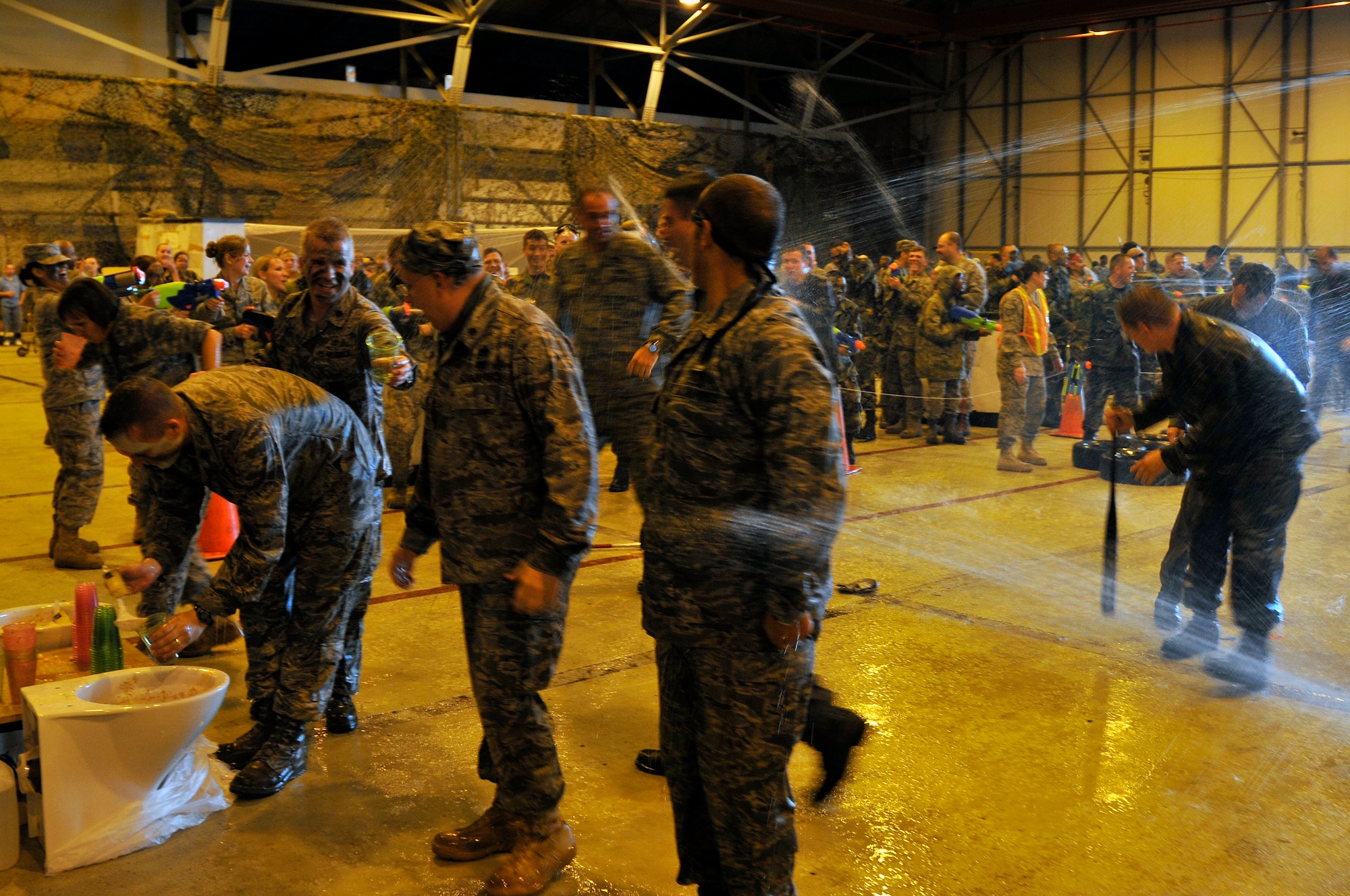 48th Fighter Wing squadron commanders get an extra soaking from their Airmen after they were ordered by 48th Fighter Wing commander to go through the obstacle course and drink from the grog bowl during the Liberty Wing's Combat Dining In June 19, 2009 at RAF Lakenheath, England. The event was hosted by the Liberty Wing 56. (U.S. Air Force photo by Airman 1st Class Perry Aston)(Released)