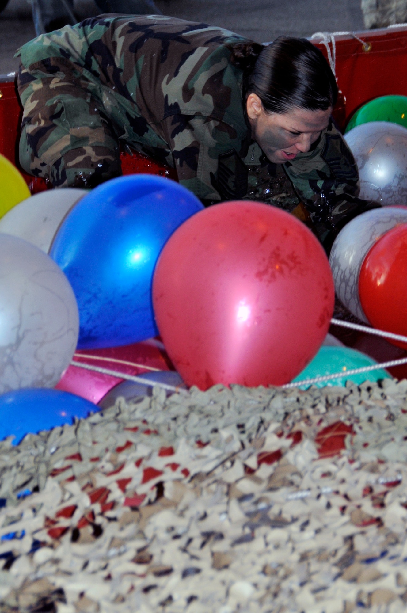 Master Sgt. Tammy Cope, 48th Force Support Squadron, dives in to the pool at the beginning of the obstacle course, after being ordered to take a drink from the grog bowl June 19, 2009 at RAF Lakenheath, England. Airmen who broke the rules of engagement for the combat dining in had to go through the obstacle course and drink the grog. (U.S. Air Force photo by Airman 1st Class Perry Aston) (Released)