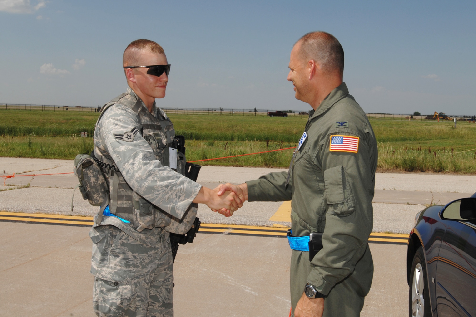 MCCONNELL AIR FORCE BASE, Kan.-- Airman 1st Class Eric Hargarten, 22nd Security Forces Squadron, receives a coin on the flight line, from Col. James C. Vechery, 22nd Air Refueling Wing commander. Airman Hargarten was “coined” by Colonel Vechery after providing an outstanding post briefing at the force generation area, June 24. (Photo by Staff Sgt. Jamie Train)