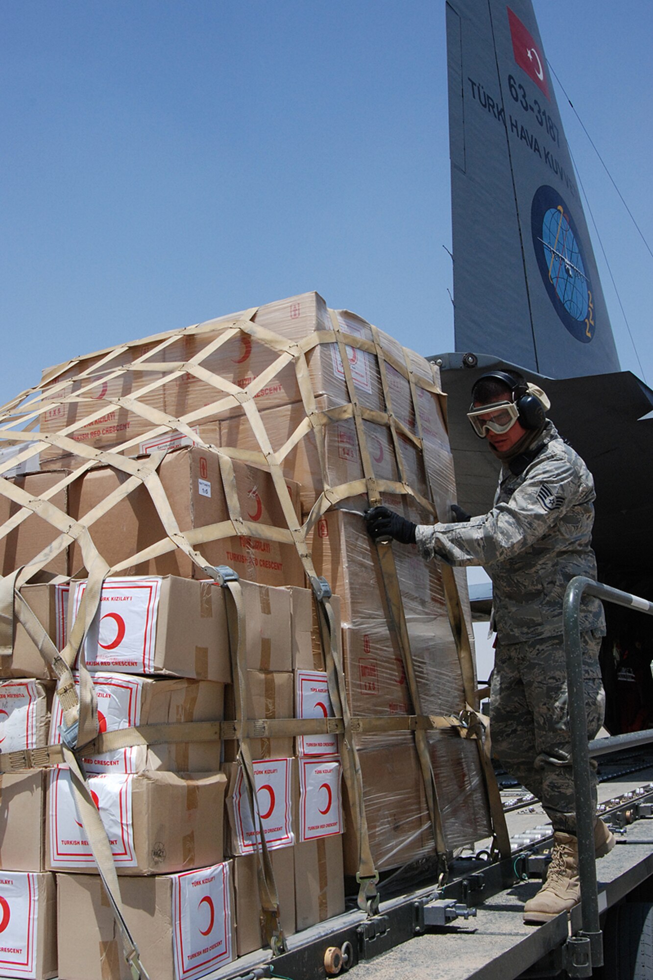KIRKUK REGIONAL AIR BASE, Iraq – Staff Sgt. Jesus Aguilar, 506th Expeditionary Logistics Squadron Aerial Port Squadron ramp commander, pushes one of five cargo pallets loaded with relief supplies on to a 60K loader from a Turkish C-130 here June 22. Sergeant Aguilar was one of almost 20 ELRS Airmen involved in the download of 12 tons of supplies including 90 blankets, 400 tents, kitchen equipment, food and more. ELRS aerial porters also helped reconfigure the airplane to carry the 11 patients, who were victims of a June 20 suicide truck bombing in Taza District south of Kirkuk city. More than 80 people were killed and 250 injured in the blast. Sergeant Aguilar is a native of Riverside, Calif., and is deployed here from the 50th Aerial Port Squadron, March Air Reserve Base, Calif. (U.S. Air Force photo / Senior Master Sgt. Michael Land)
