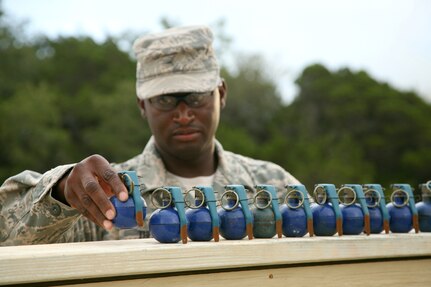 Tech. Sgt. Eric Thomas, an instructor with the 343rd Training Squadron, preps M-67 training grenades June 18 at Camp Bullis, Texas.  Students practice throwing the simulated grenades to hone their technique as instructors evaluate before moving on to live ordnance. (U.S. Air Force photo/Robbin Cresswell)

