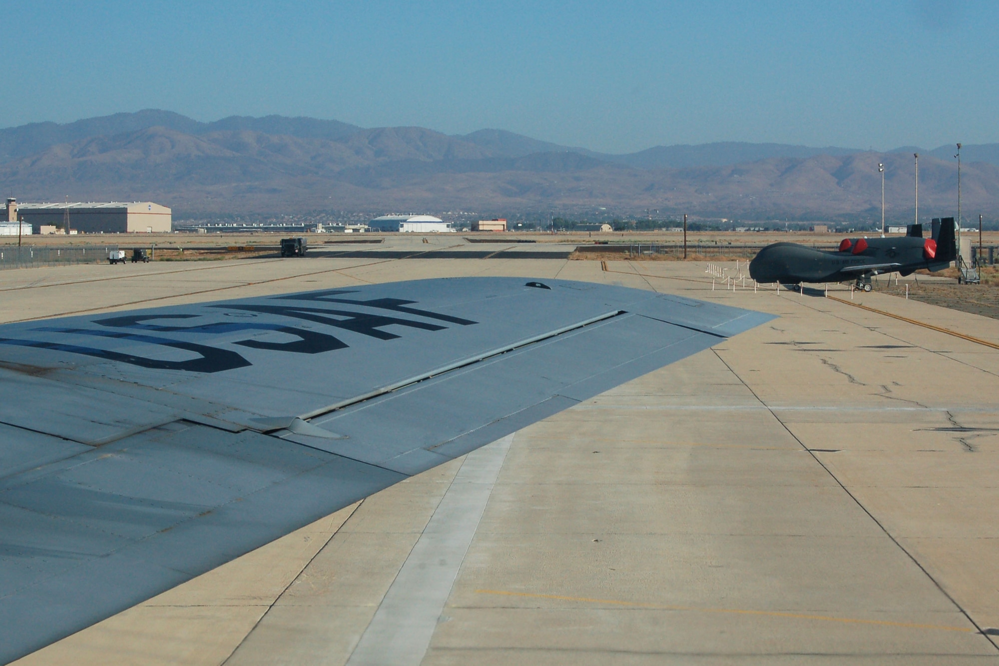 The wing of a Grand Forks AFB KC-135 Stratotanker seems to point out a Block 30 Global Hawk on the flightline of Air Force Site 42 in Palmdale, Calif., June 24. Seven Airmen on board the refueler were invited to attend the unvieling of the next generation Global Hawk, the Block 40, during a ceremony held June 25.

